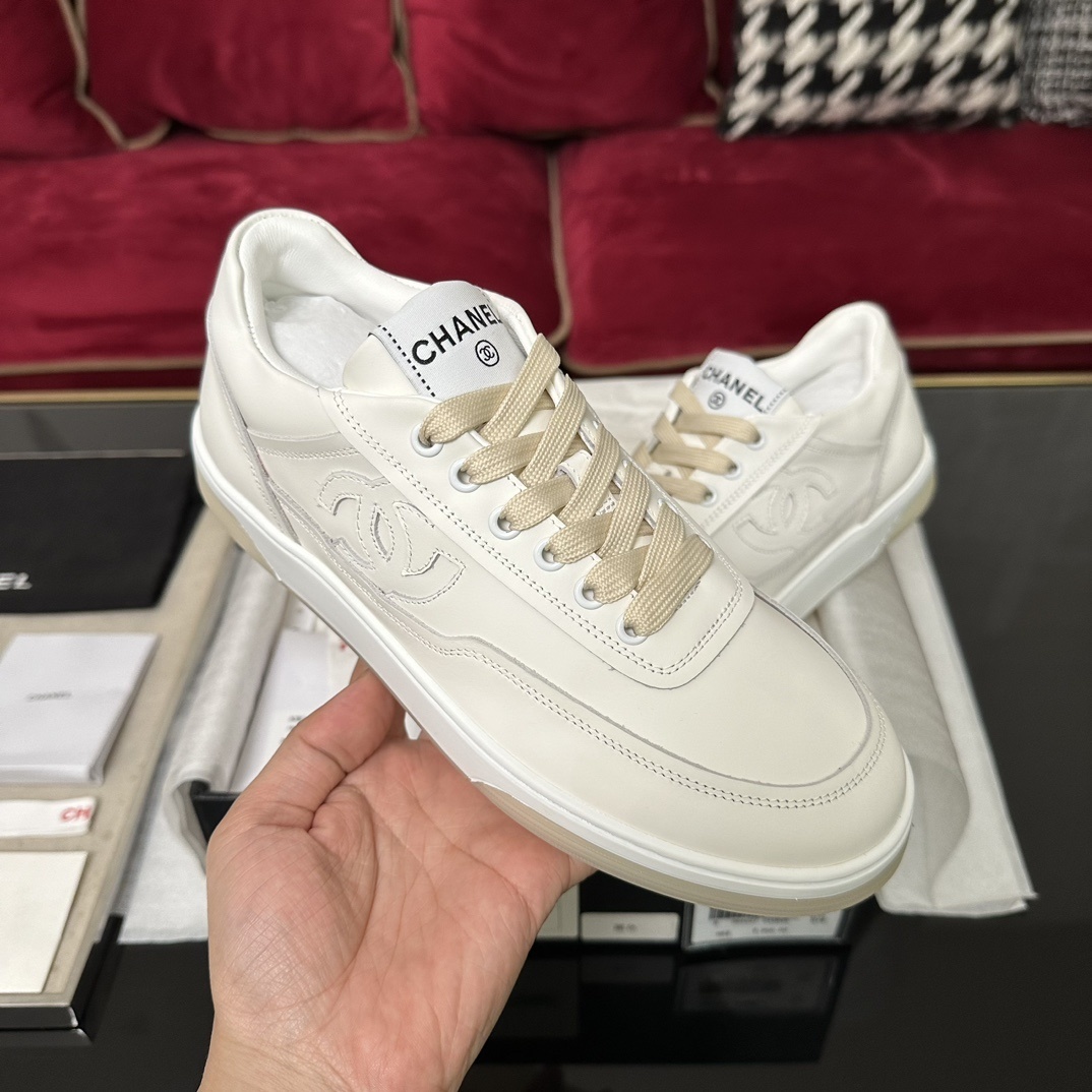 Authentic white Chanel leather sneakers with embossed CC logo and cream laces in original luxury packaging. - Hình 4