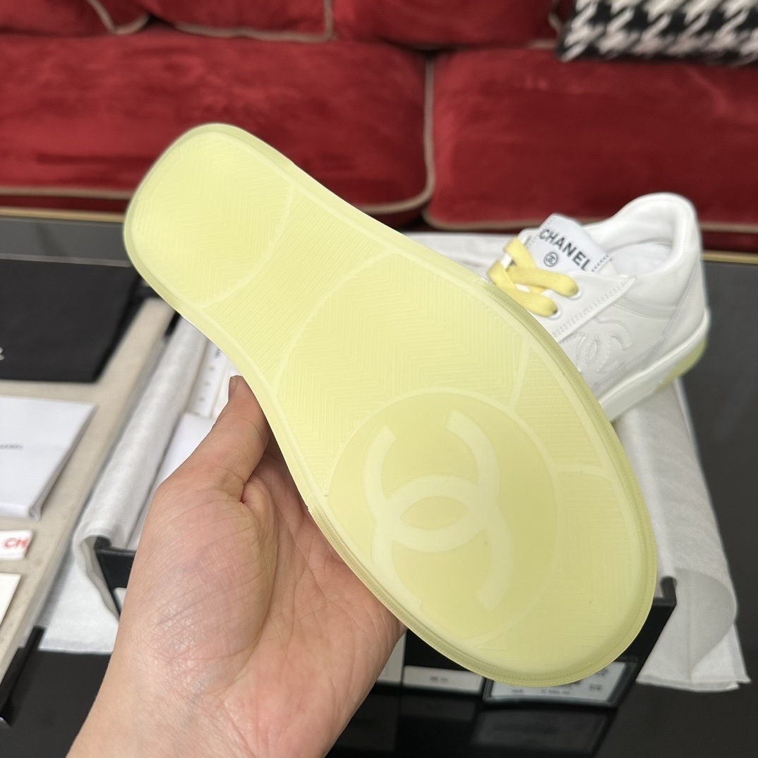 Pair of Chanel white leather sneakers with yellow laces and translucent yellow sole in a black designer box - Hình 9