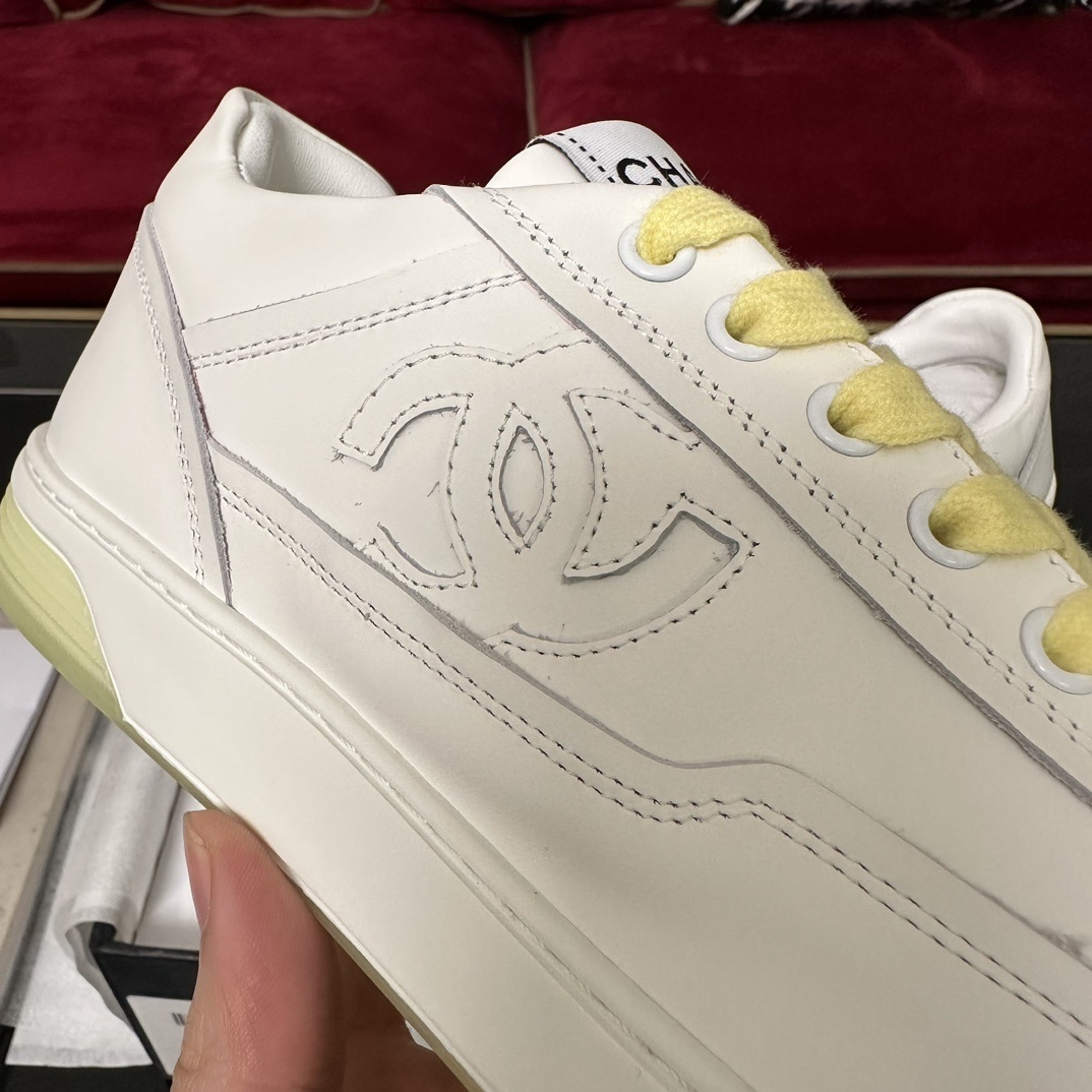 Pair of Chanel white leather sneakers with yellow laces and translucent yellow sole in a black designer box - Hình 7