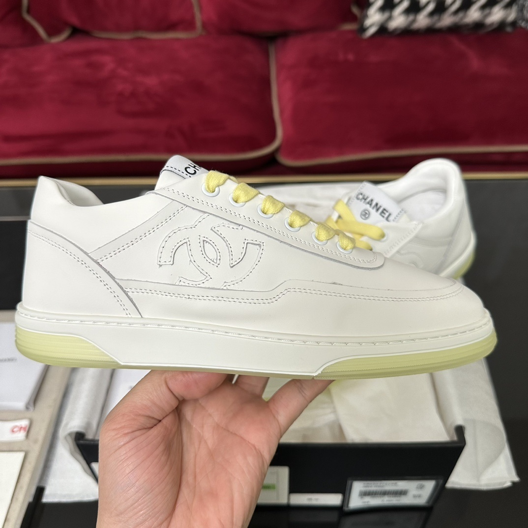 Pair of Chanel white leather sneakers with yellow laces and translucent yellow sole in a black designer box - Hình 5