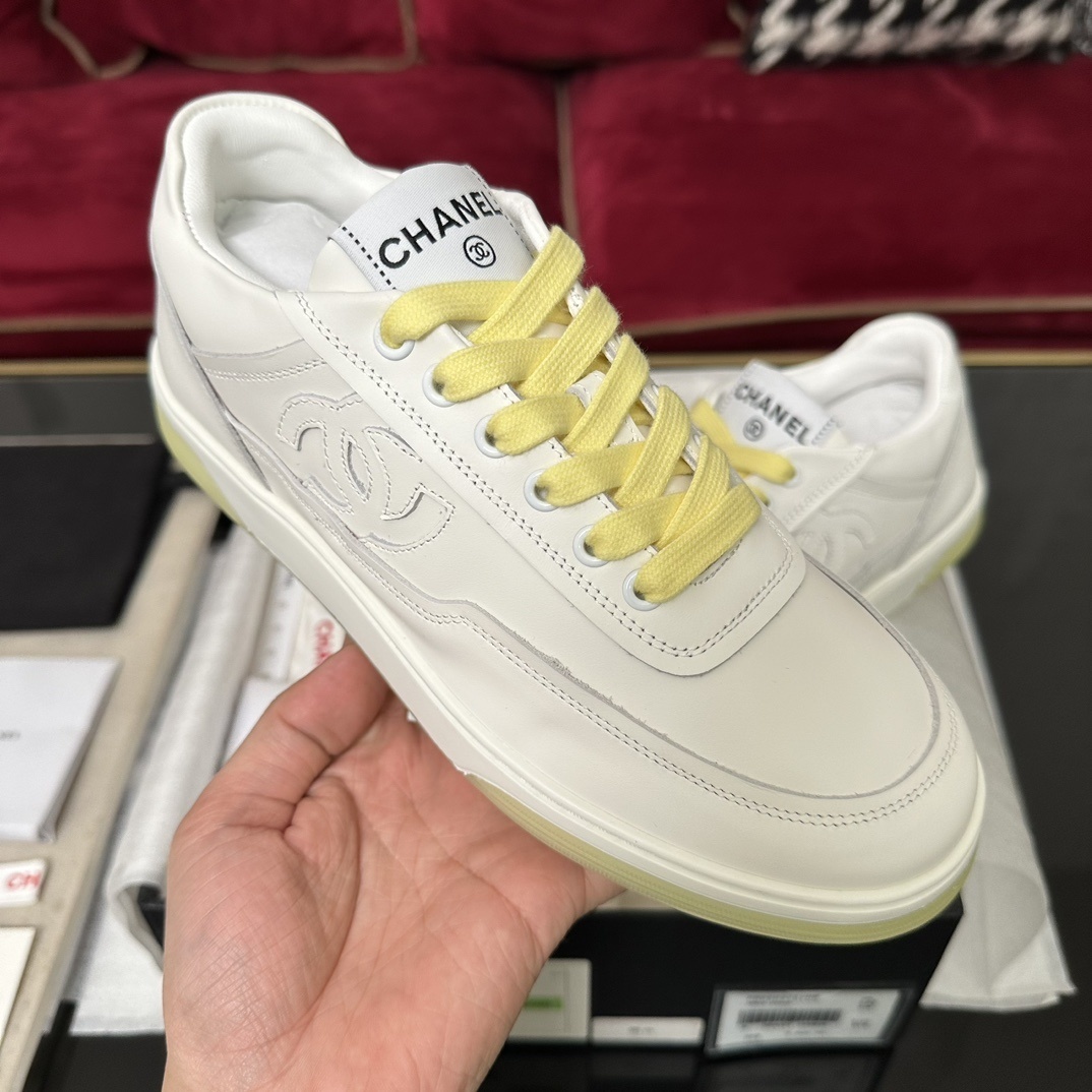 Pair of Chanel white leather sneakers with yellow laces and translucent yellow sole in a black designer box - Hình 4