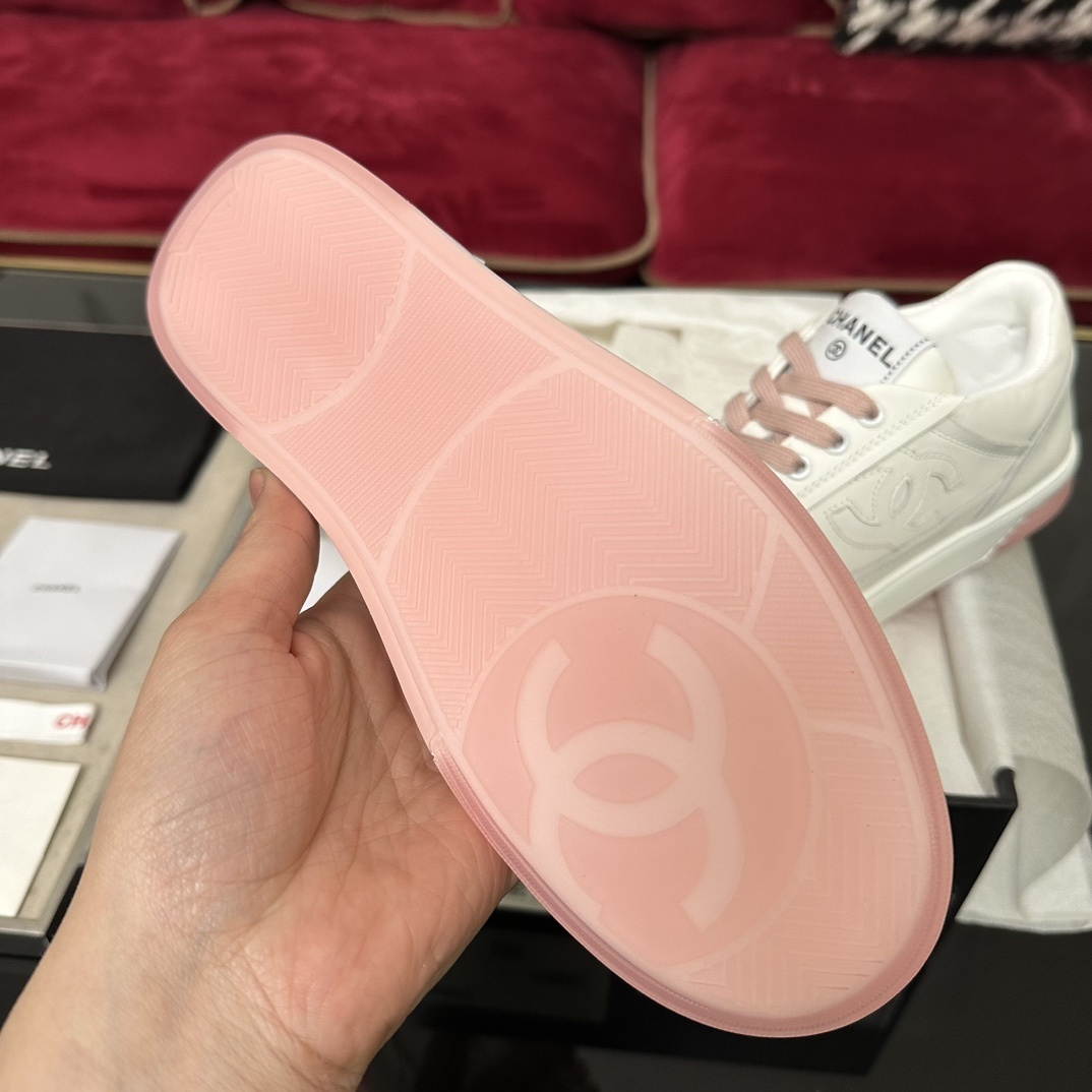 Luxury Chanel white leather sneakers with pink laces and translucent pink soles in a black designer box. - Hình 9