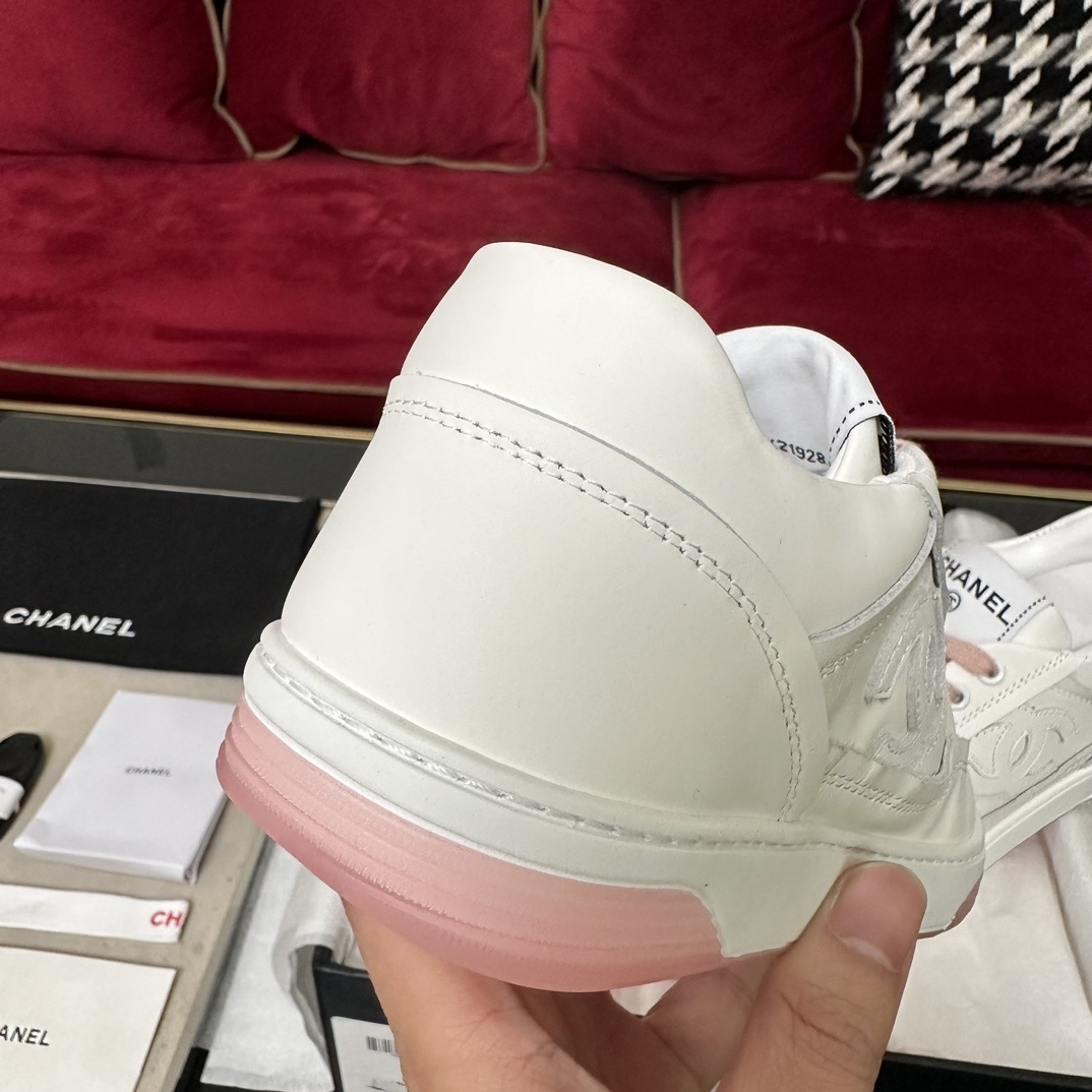 Luxury Chanel white leather sneakers with pink laces and translucent pink soles in a black designer box. - Hình 8