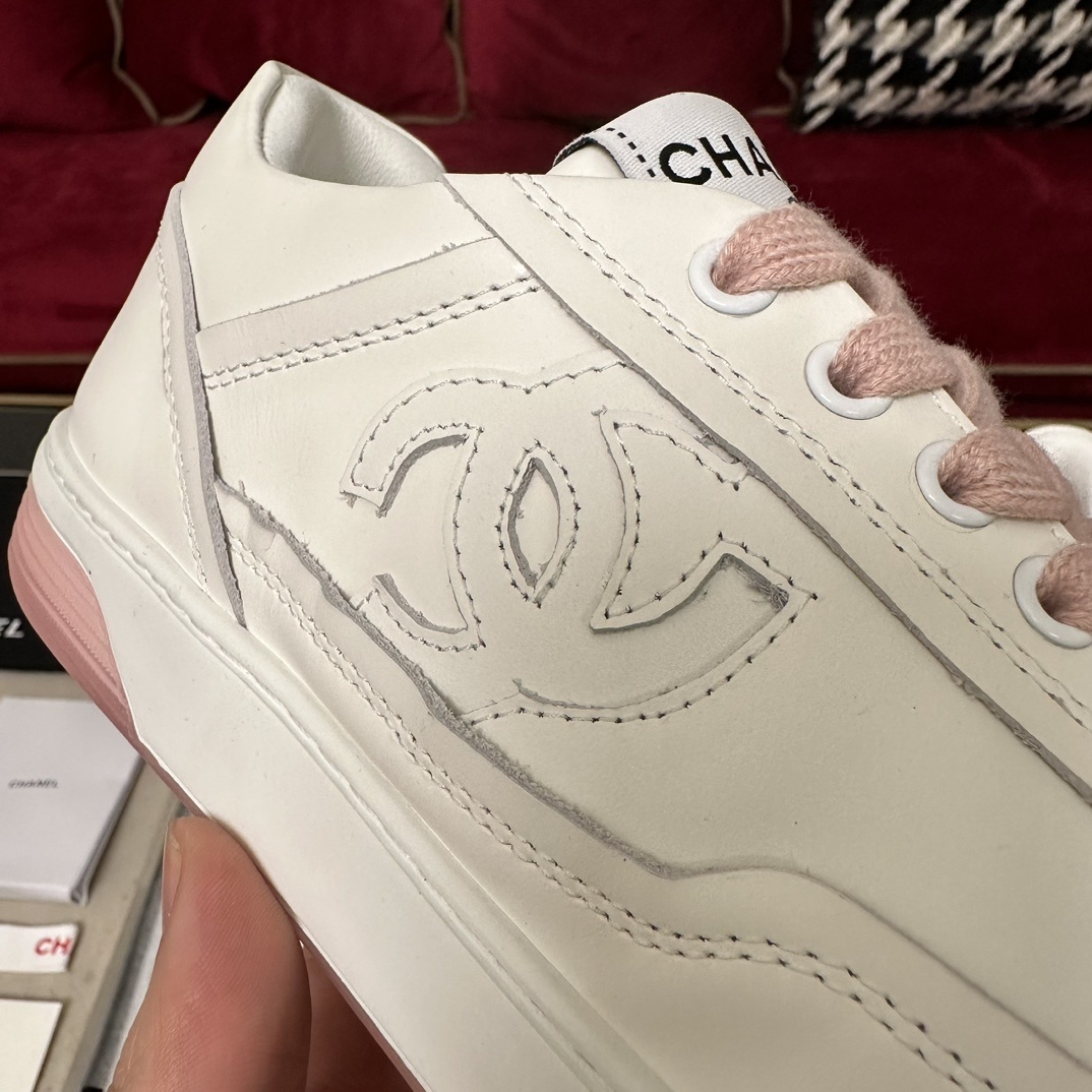 Luxury Chanel white leather sneakers with pink laces and translucent pink soles in a black designer box. - Hình 7