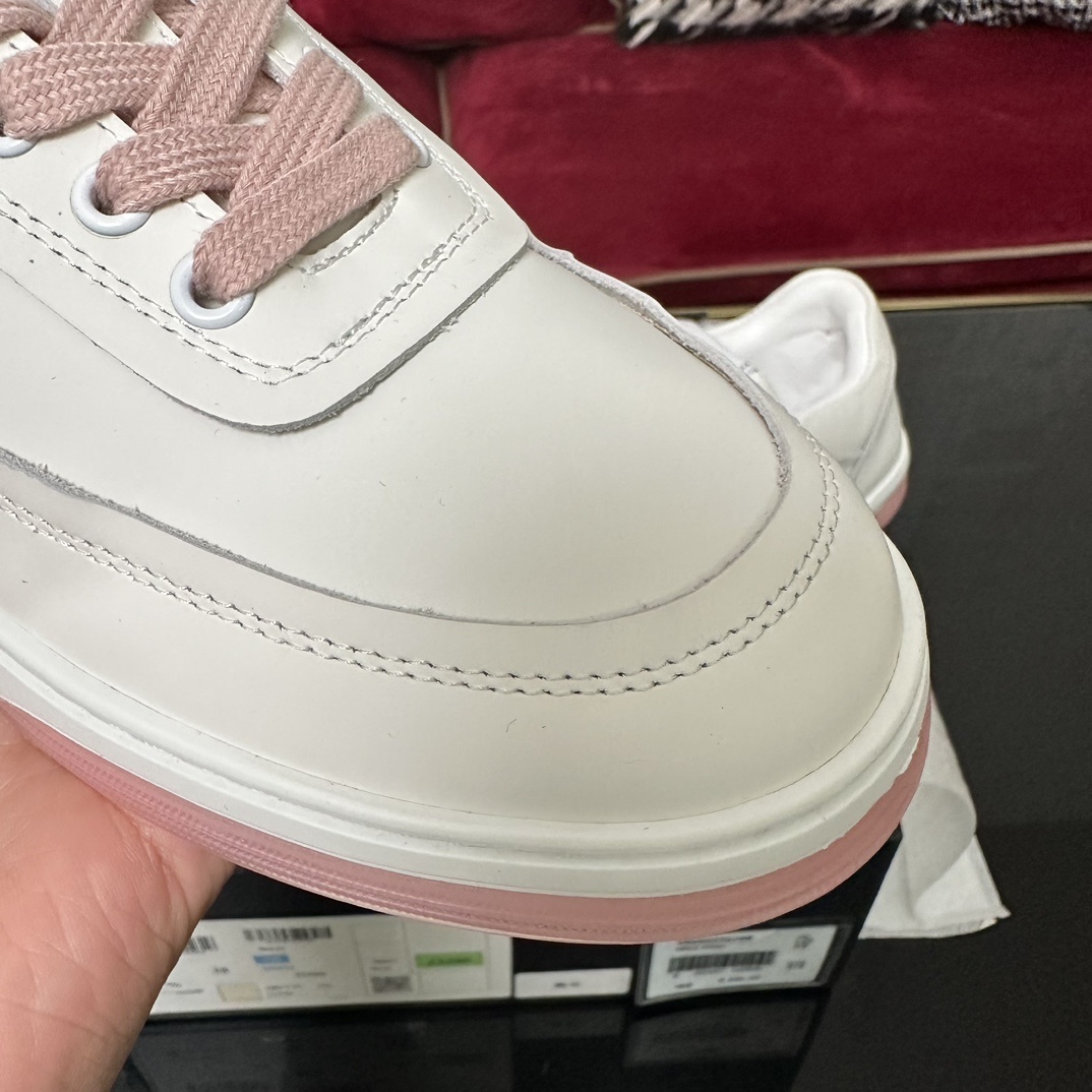 Luxury Chanel white leather sneakers with pink laces and translucent pink soles in a black designer box. - Hình 6