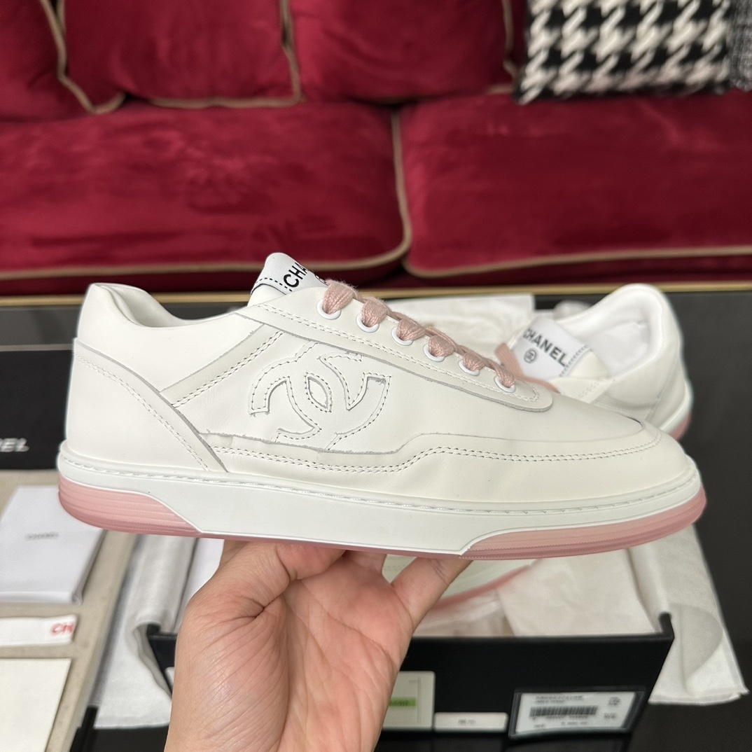 Luxury Chanel white leather sneakers with pink laces and translucent pink soles in a black designer box. - Hình 5