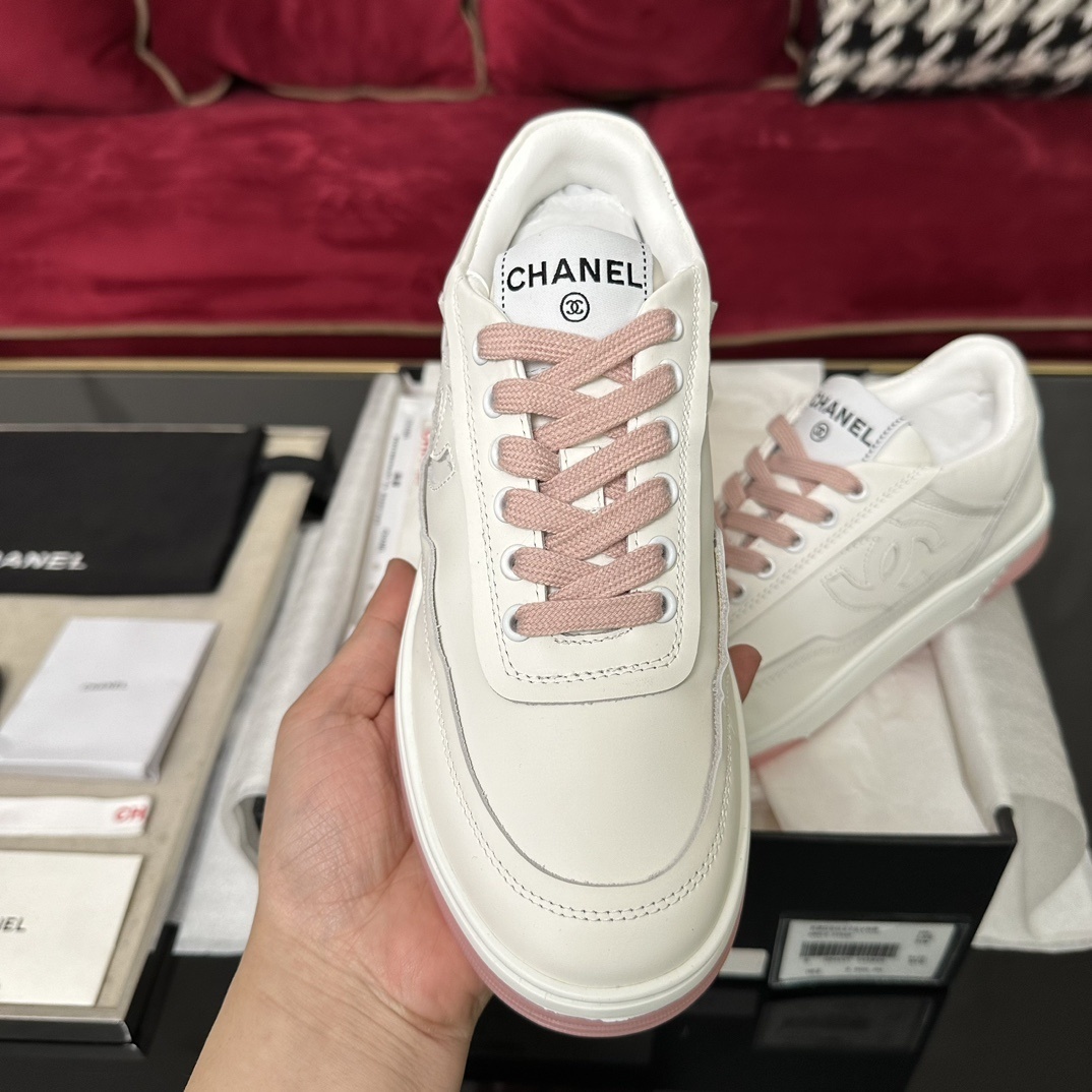 Luxury Chanel white leather sneakers with pink laces and translucent pink soles in a black designer box. - Hình 3