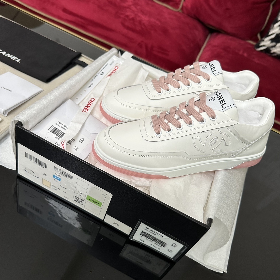 Luxury Chanel white leather sneakers with pink laces and translucent pink soles in a black designer box. - Hình 2