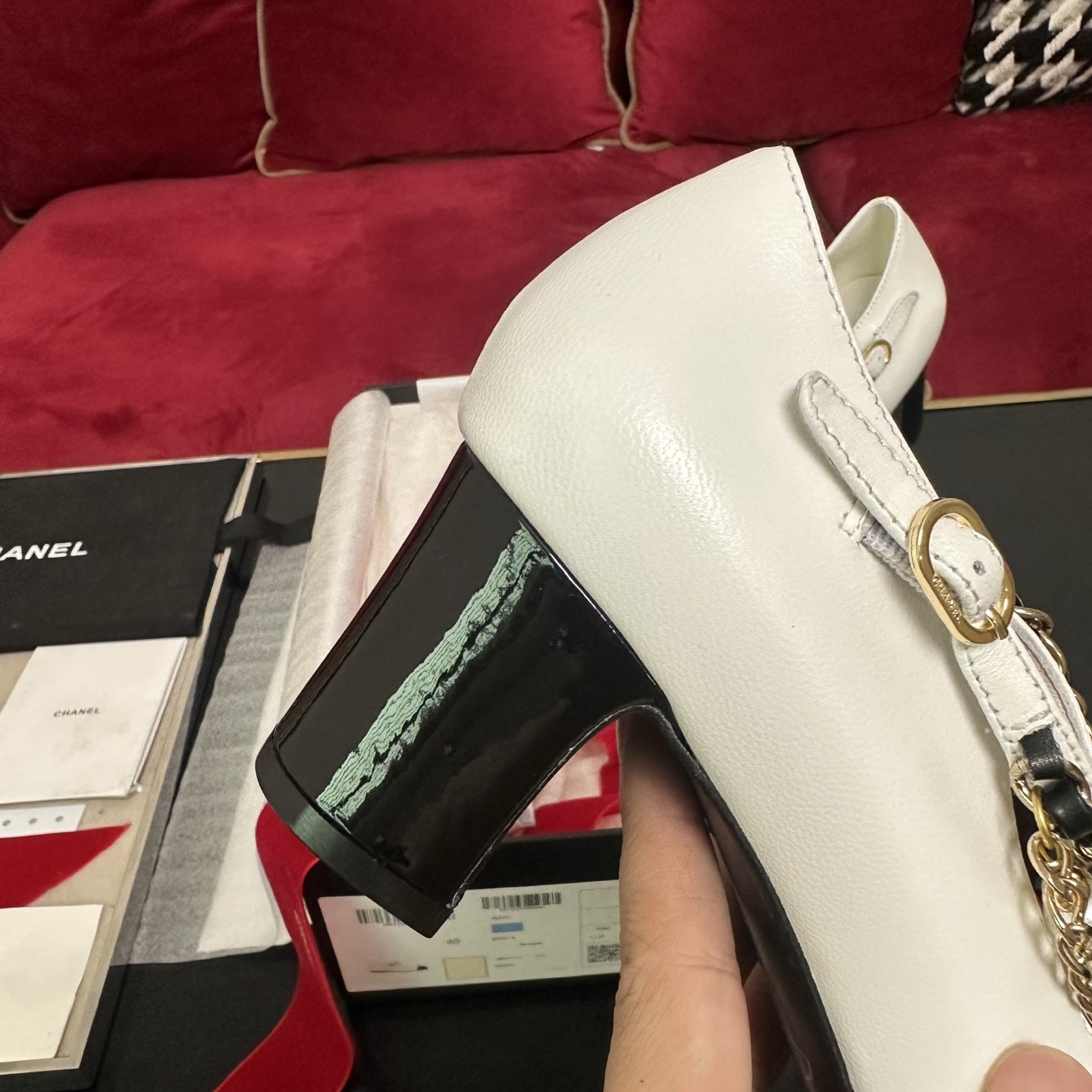 Pair of white Chanel Mary Jane pumps with black patent leather cap toes and decorative pearl and gold chain ankle straps in a luxury box. - Hình 8