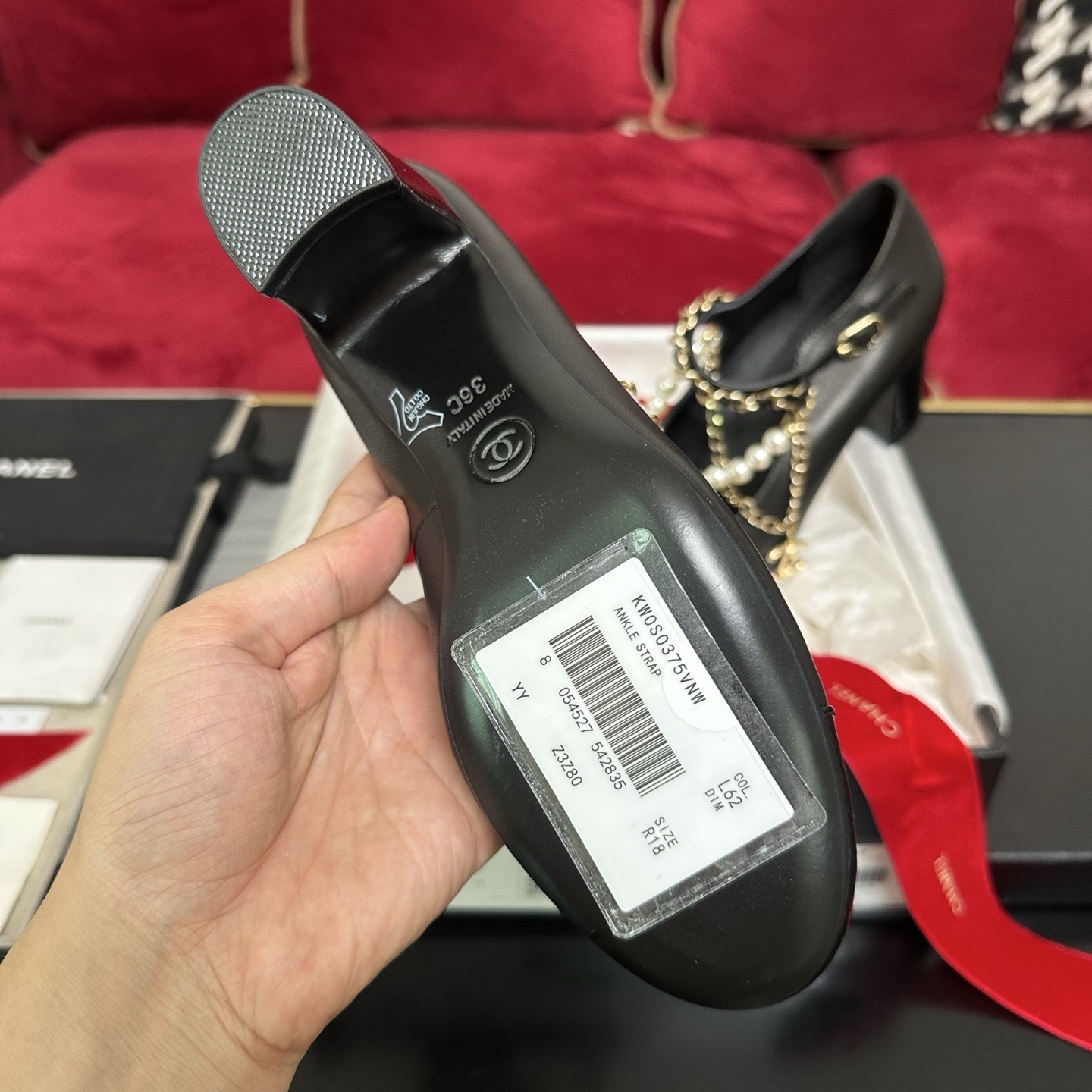 Luxury black Chanel Mary Jane pumps with patent leather cap toes and decorative pearl and gold chain straps displayed in a branded box. - Hình 9