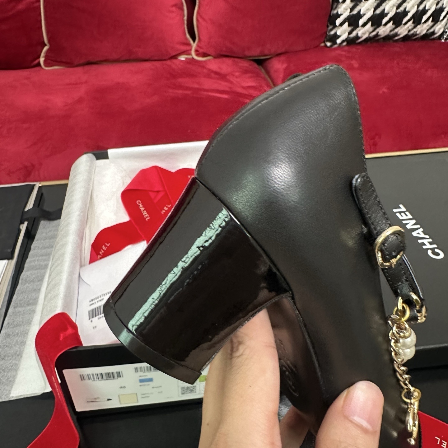 Luxury black Chanel Mary Jane pumps with patent leather cap toes and decorative pearl and gold chain straps displayed in a branded box. - Hình 8