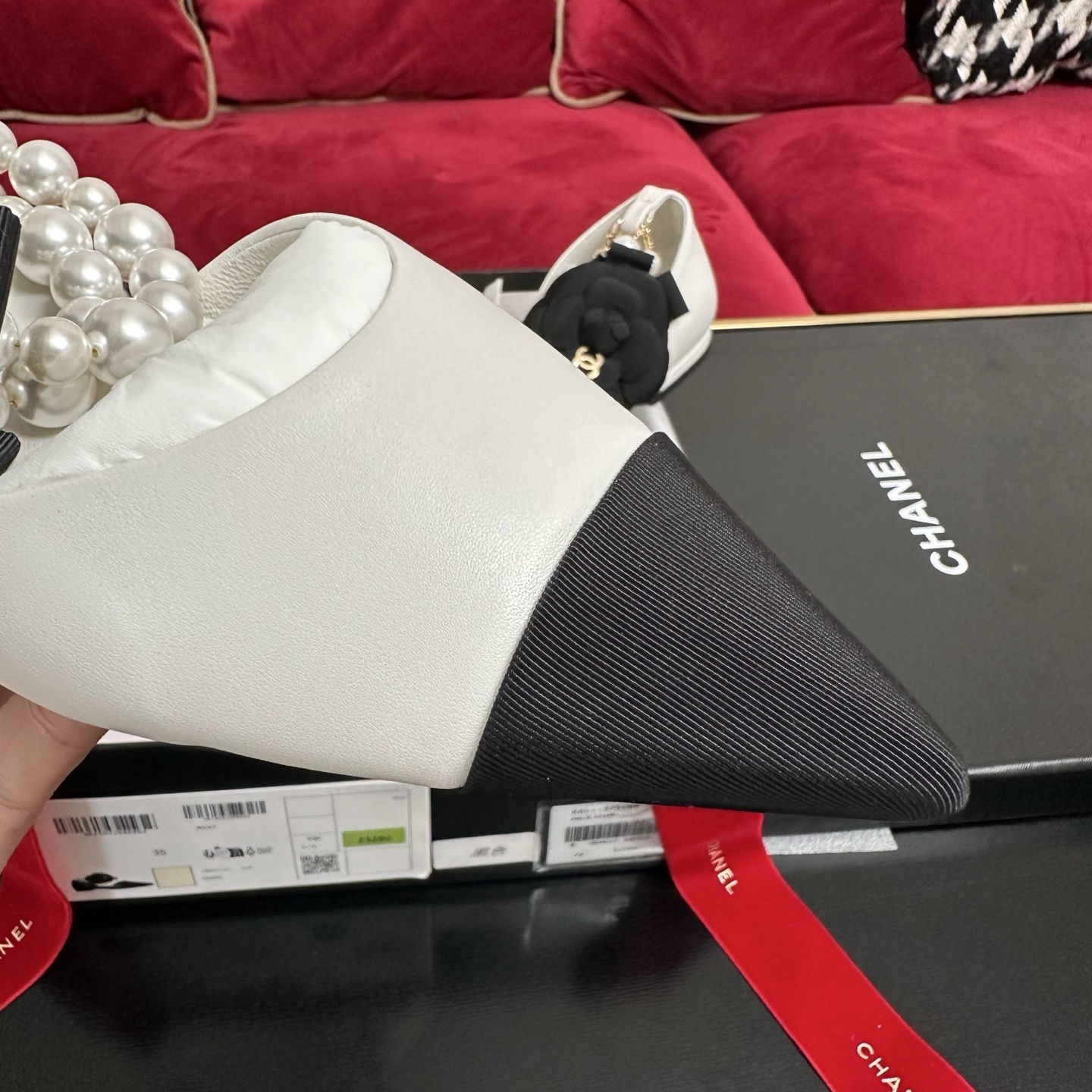 Chanel white leather mules with black cap toe, pearl ankle strap, and black camellia flower charm in original packaging. - Hình 6