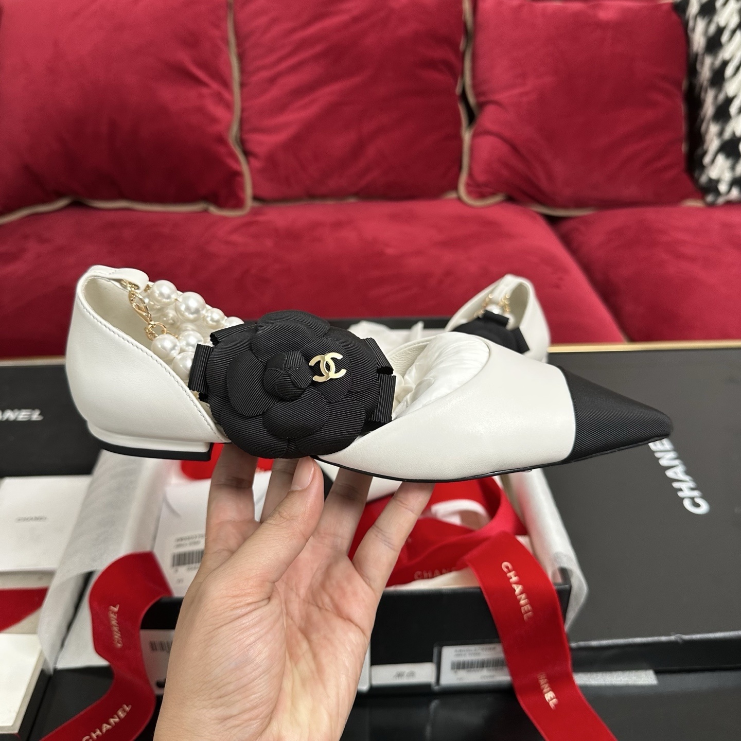 Chanel white leather mules with black cap toe, pearl ankle strap, and black camellia flower charm in original packaging. - Hình 5