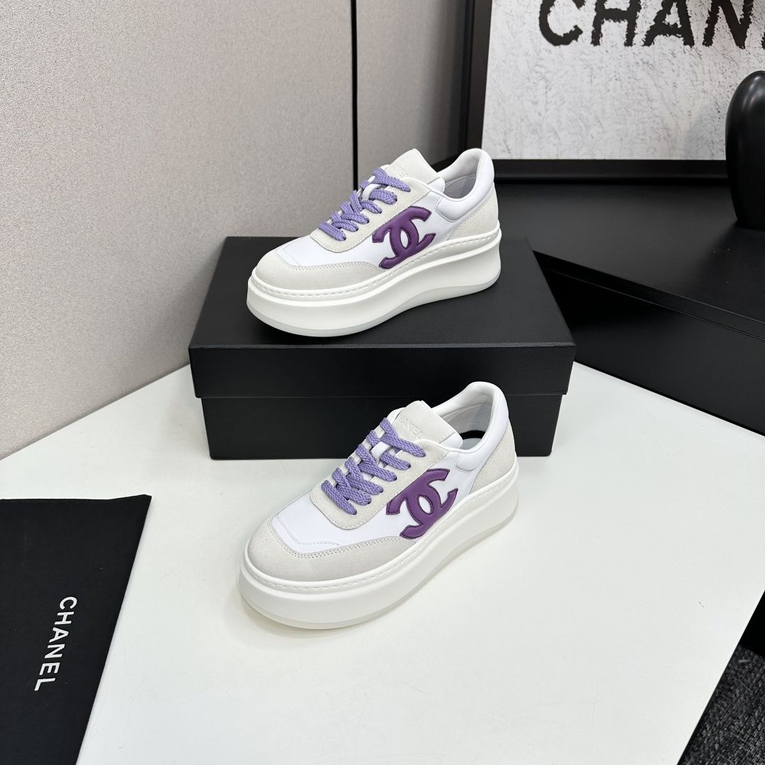Chanel white leather and suede platform sneakers featuring a purple interlocking CC logo and purple laces on a black display box. - Hình 2