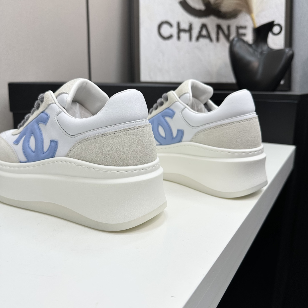 Luxury Chanel platform sneakers in white and light blue leather with suede accents on a black display box. - Hình 7