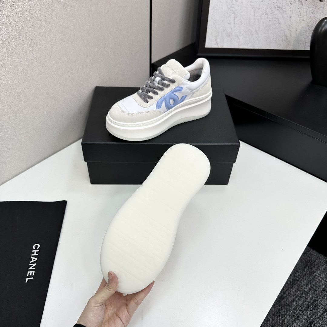 Luxury Chanel platform sneakers in white and light blue leather with suede accents on a black display box. - Hình 4