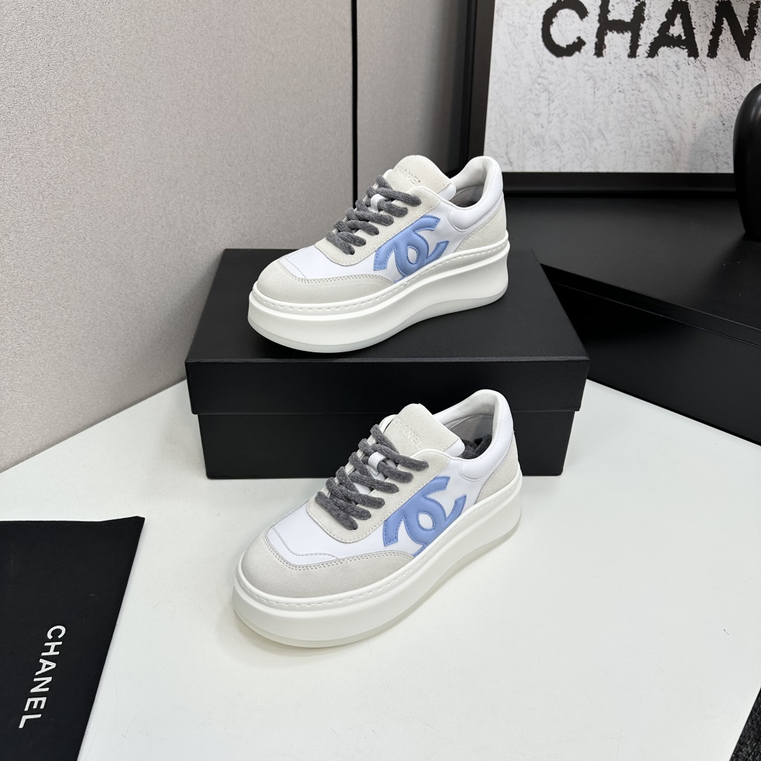 Luxury Chanel platform sneakers in white and light blue leather with suede accents on a black display box. - Hình 2