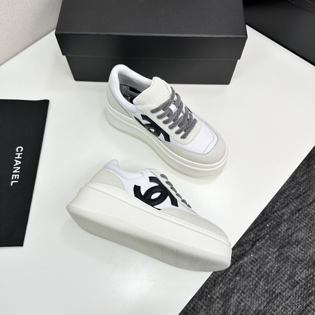 Side view of Chanel white and beige platform sneakers with black CC logo on a black box - Hình 9