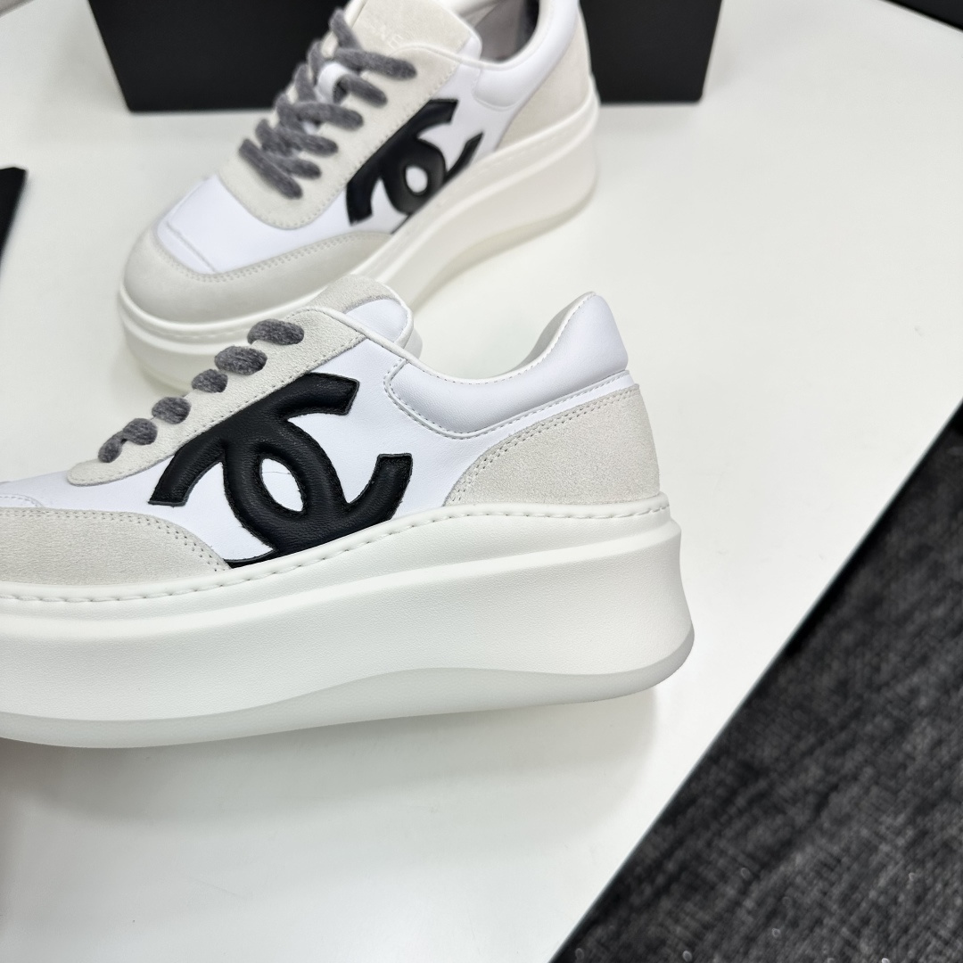 Side view of Chanel white and beige platform sneakers with black CC logo on a black box - Hình 7