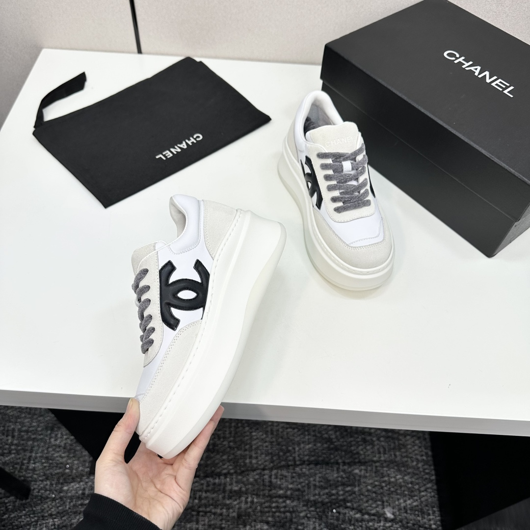 Side view of Chanel white and beige platform sneakers with black CC logo on a black box - Hình 2