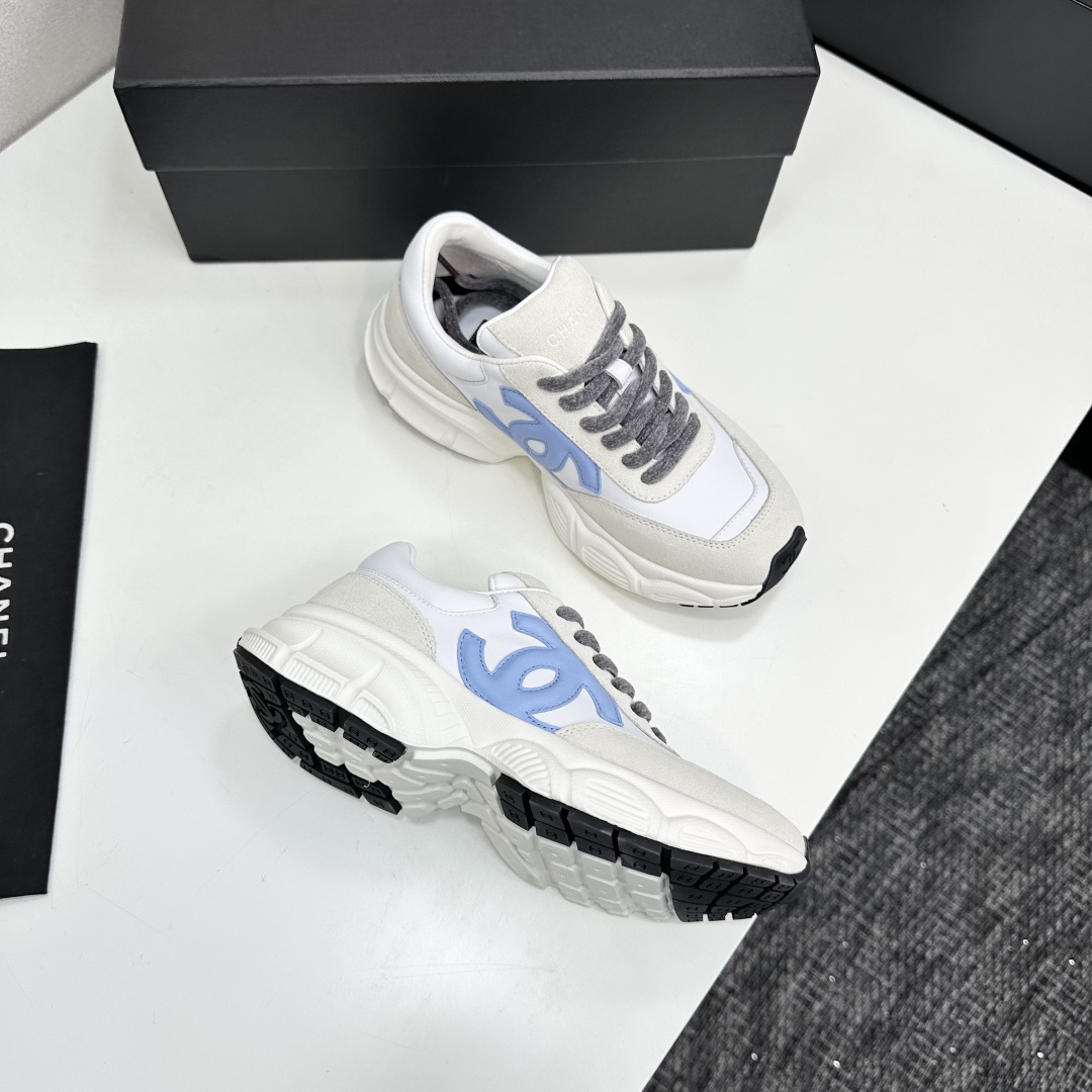 Chanel white and beige sneakers with a light blue CC logo and grey laces displayed on a black brand box - Hình 9