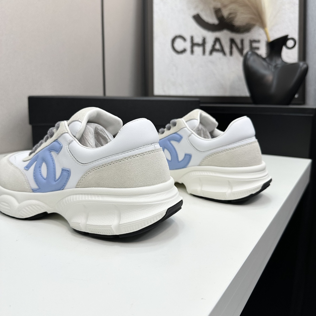 Chanel white and beige sneakers with a light blue CC logo and grey laces displayed on a black brand box - Hình 8