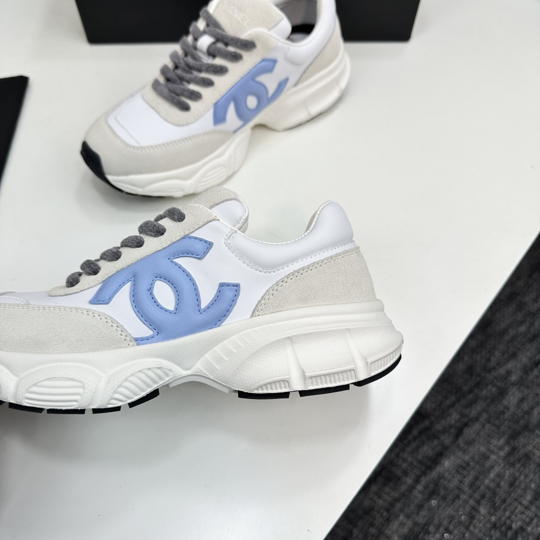 Chanel white and beige sneakers with a light blue CC logo and grey laces displayed on a black brand box - Hình 7