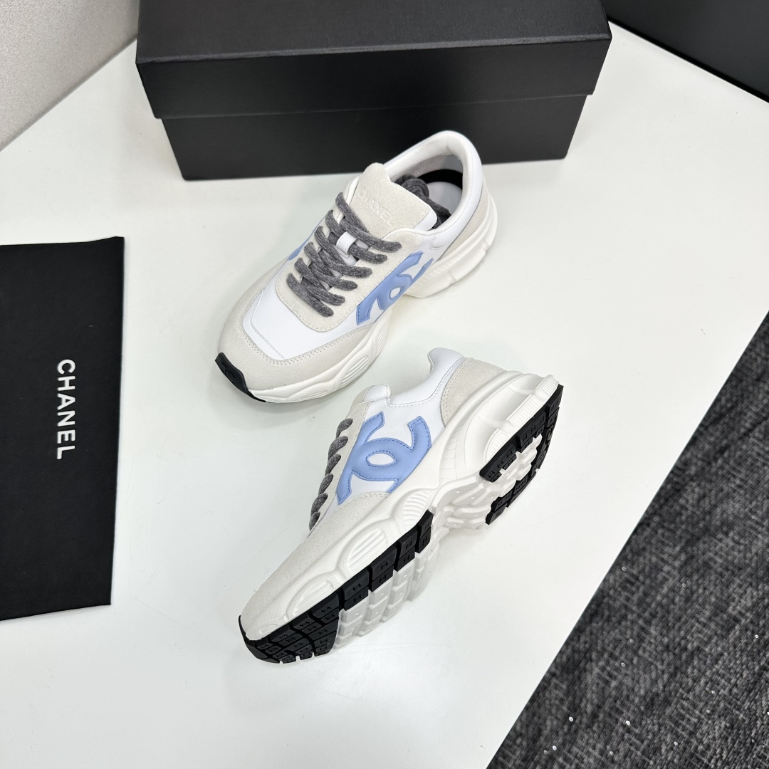 Chanel white and beige sneakers with a light blue CC logo and grey laces displayed on a black brand box - Hình 6