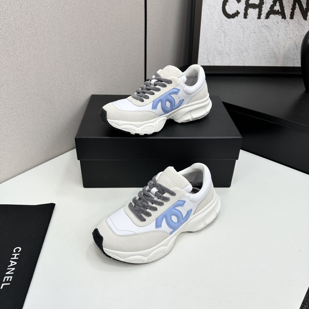 Chanel white and beige sneakers with a light blue CC logo and grey laces displayed on a black brand box - Hình 3
