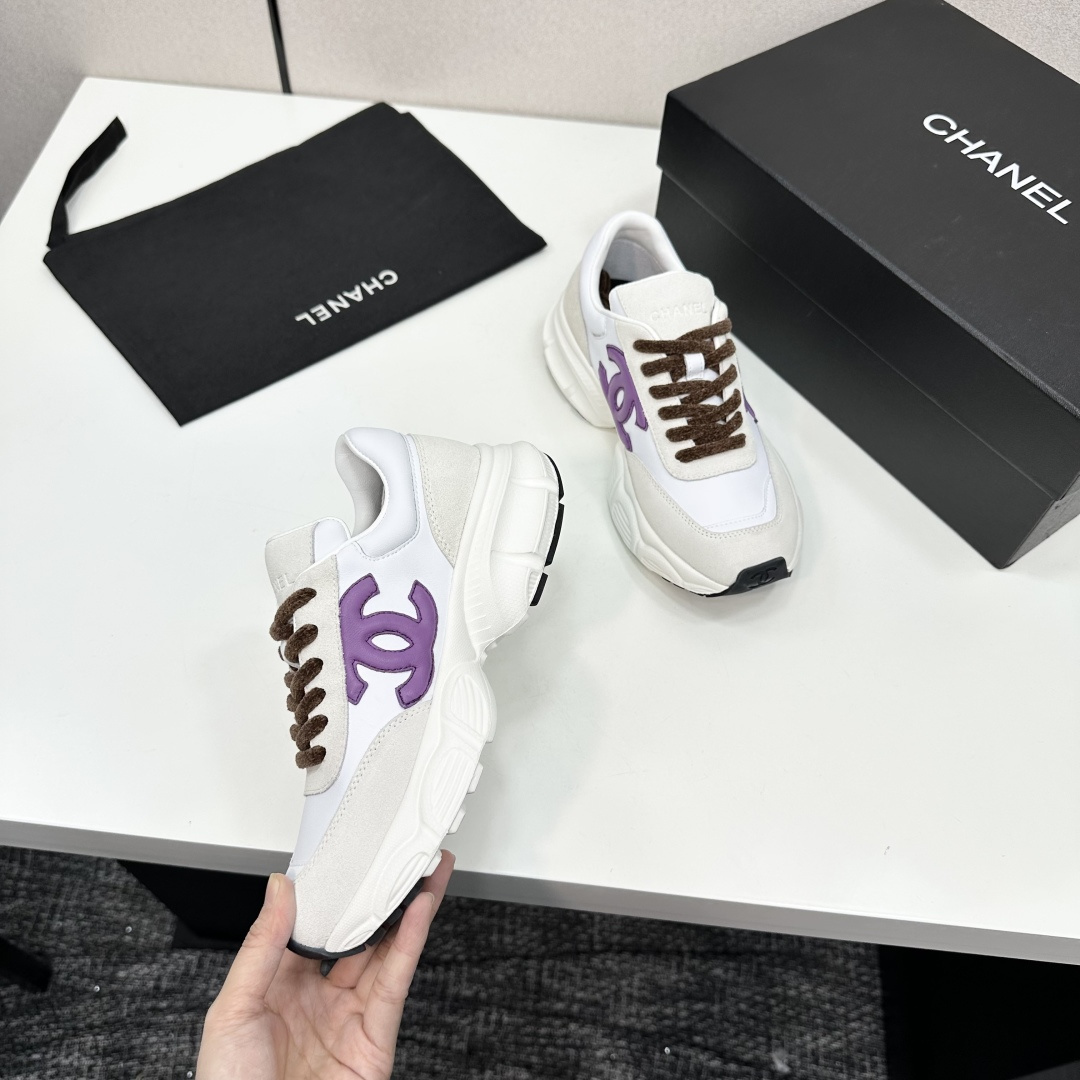 Luxury Chanel sneakers in white leather and beige suede featuring a purple CC logo and chunky white sole. - Hình 2