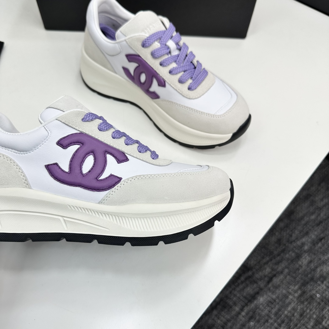 A pair of Chanel sneakers in white leather and grey suede with purple CC logo and laces on a black designer box. - Hình 10