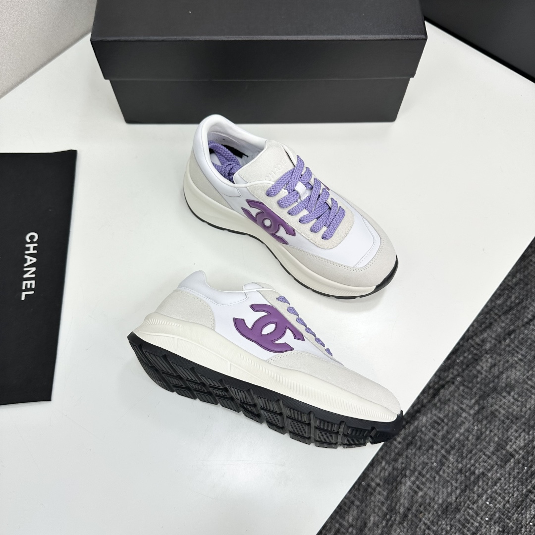 A pair of Chanel sneakers in white leather and grey suede with purple CC logo and laces on a black designer box. - Hình 9