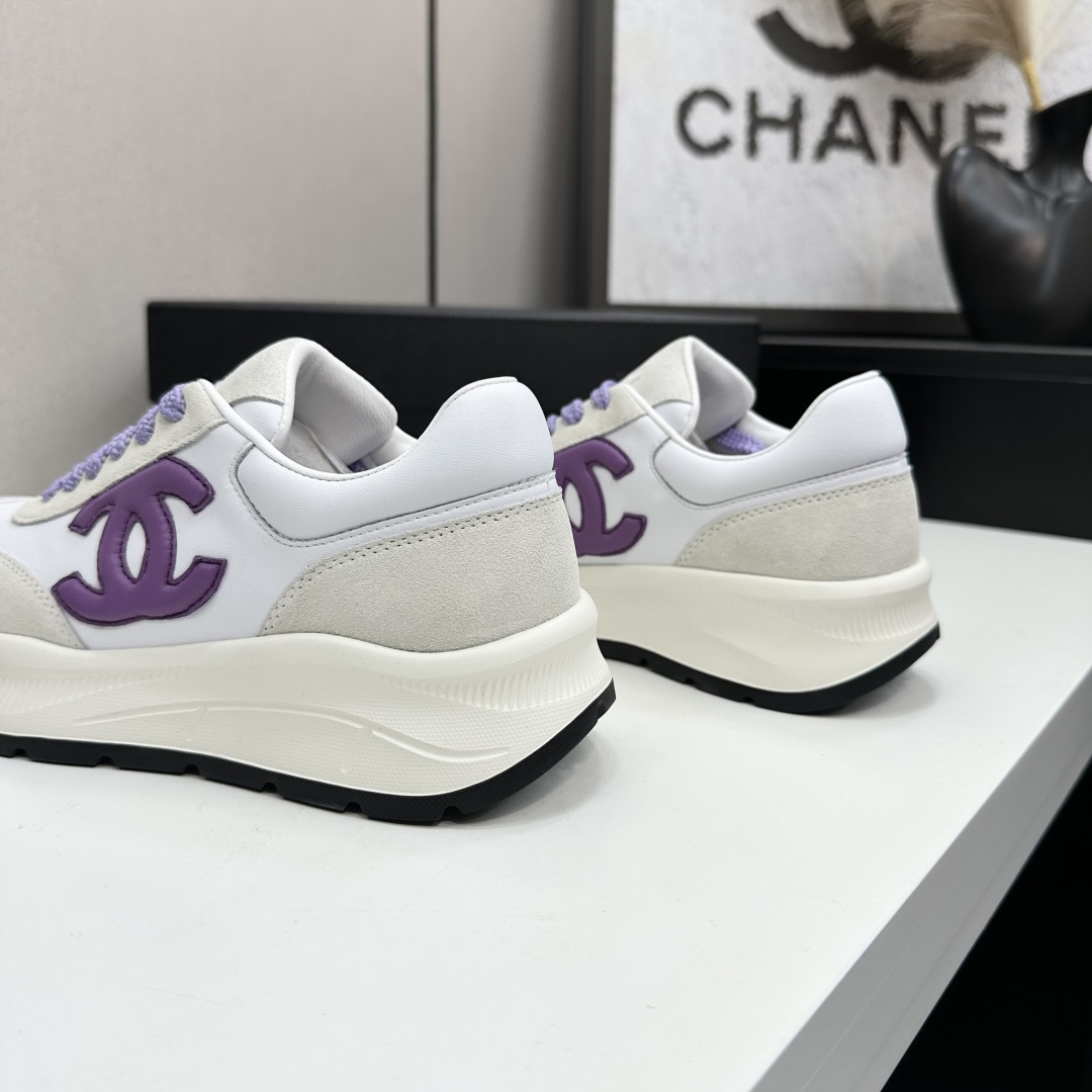 A pair of Chanel sneakers in white leather and grey suede with purple CC logo and laces on a black designer box. - Hình 8