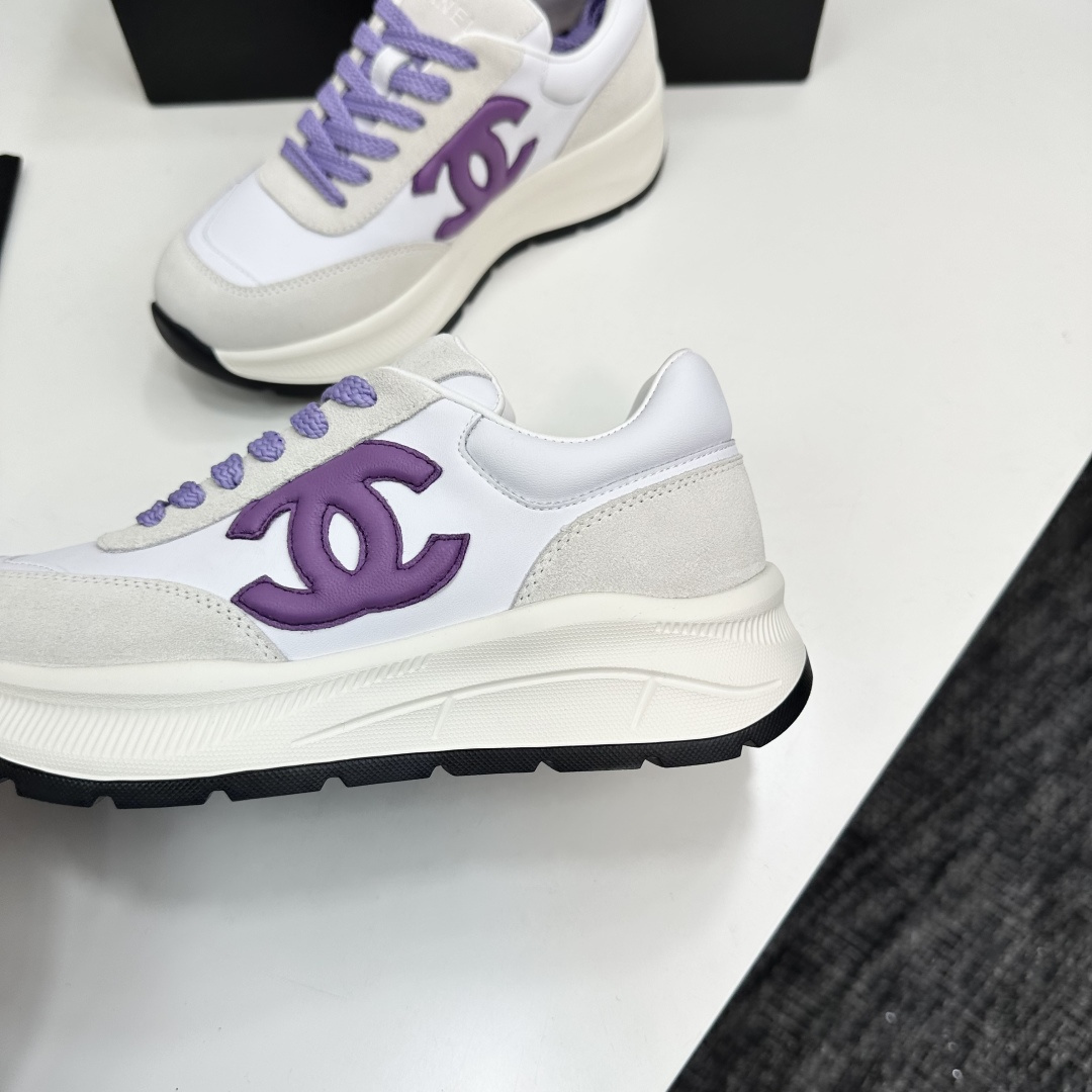 A pair of Chanel sneakers in white leather and grey suede with purple CC logo and laces on a black designer box. - Hình 7