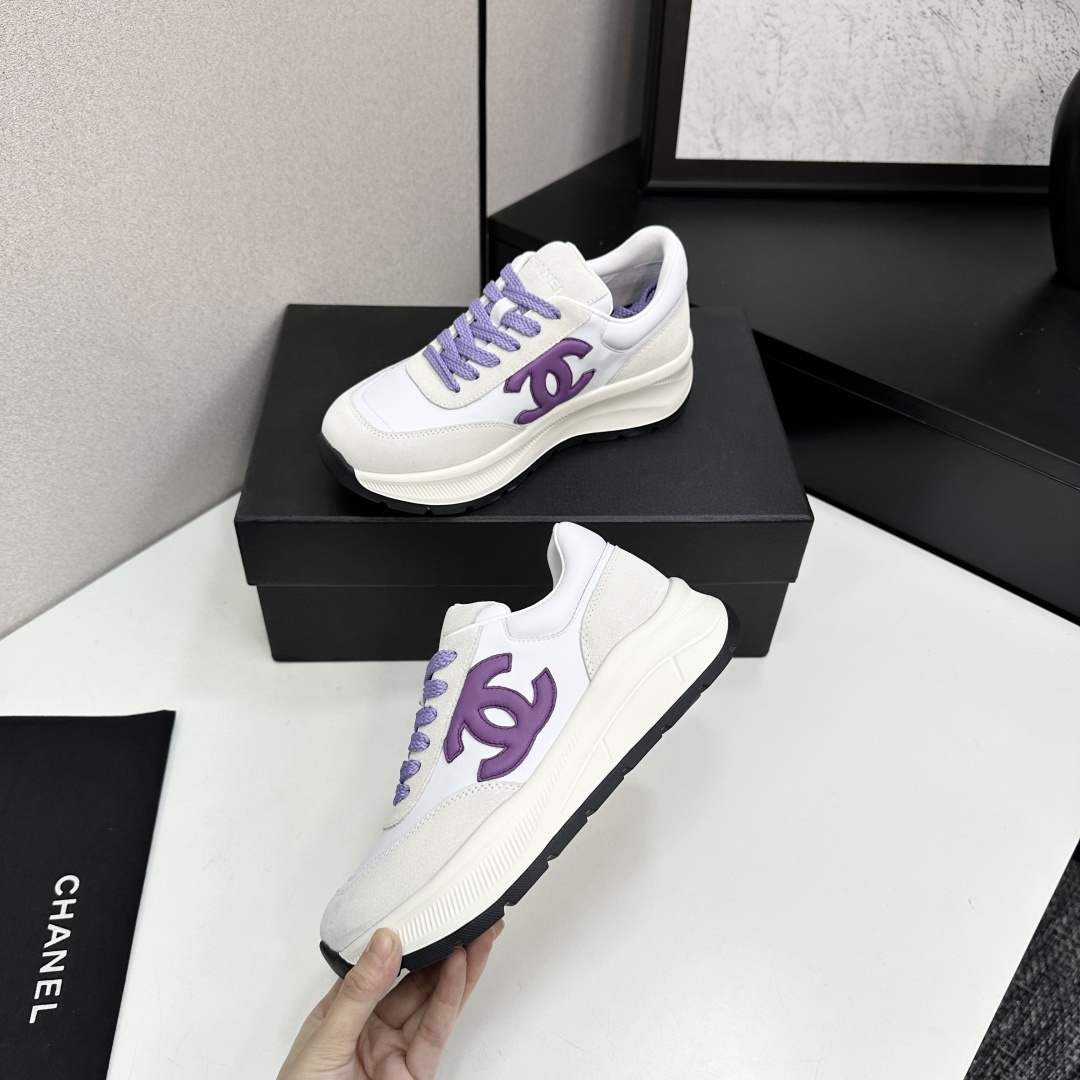 A pair of Chanel sneakers in white leather and grey suede with purple CC logo and laces on a black designer box. - Hình 4