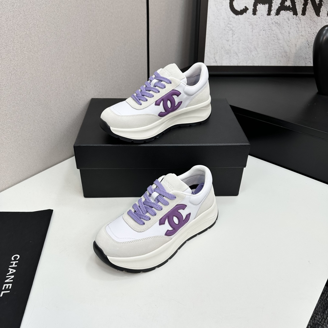 A pair of Chanel sneakers in white leather and grey suede with purple CC logo and laces on a black designer box. - Hình 3