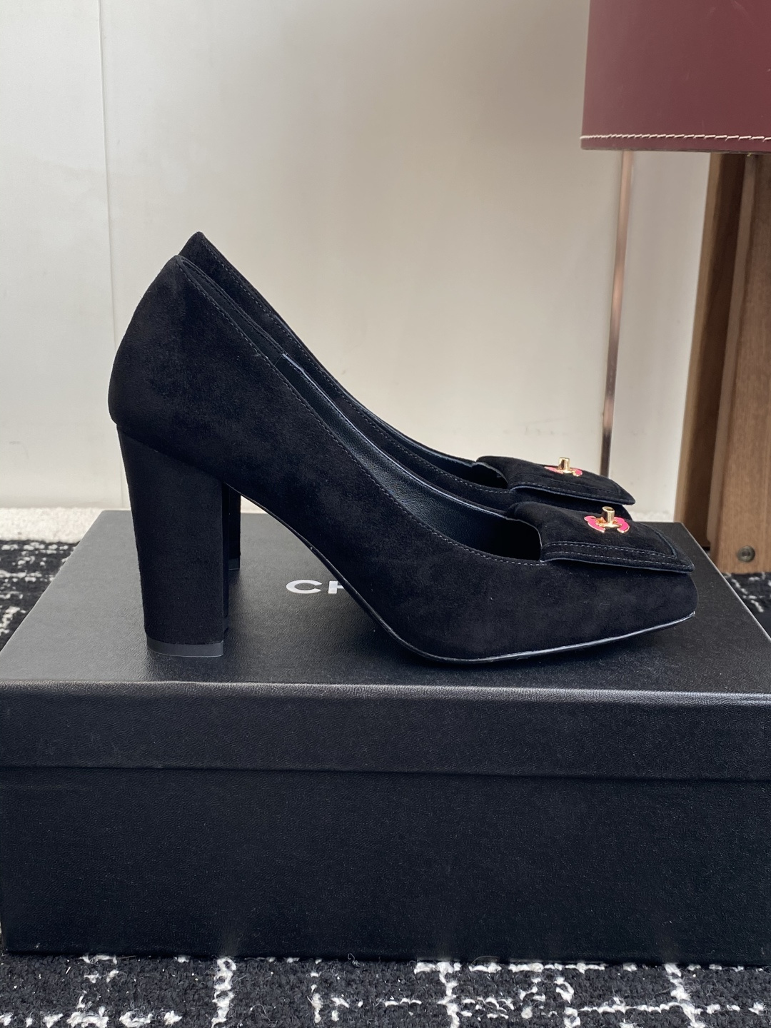 Authentic Chanel black suede pumps with square toe and pink CC logo turn-lock detail on a black box. - Hình 2