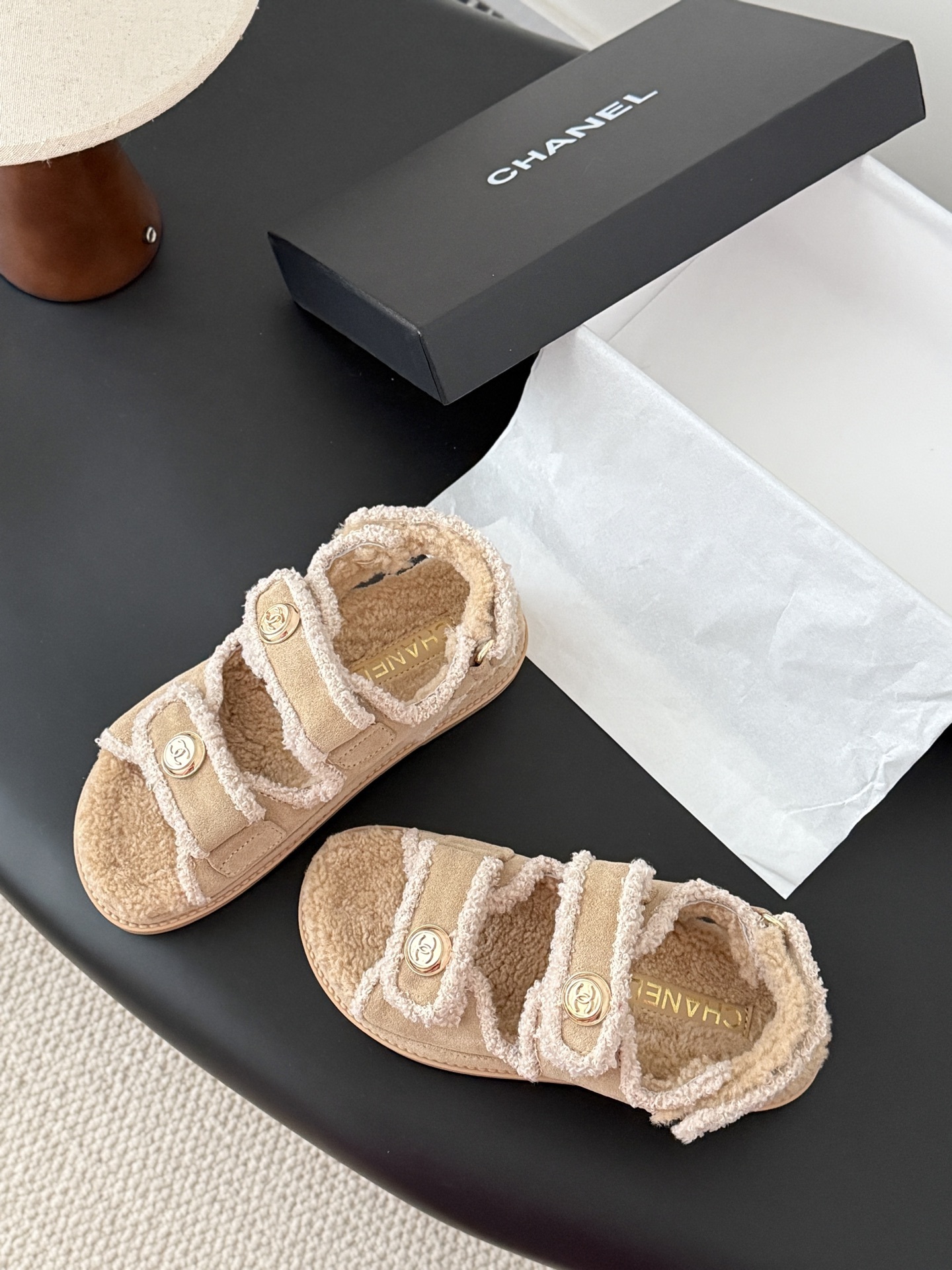 Luxury Chanel beige shearling dad sandals with gold CC logo buttons and fluffy lining placed next to a Chanel box. - Hình 3