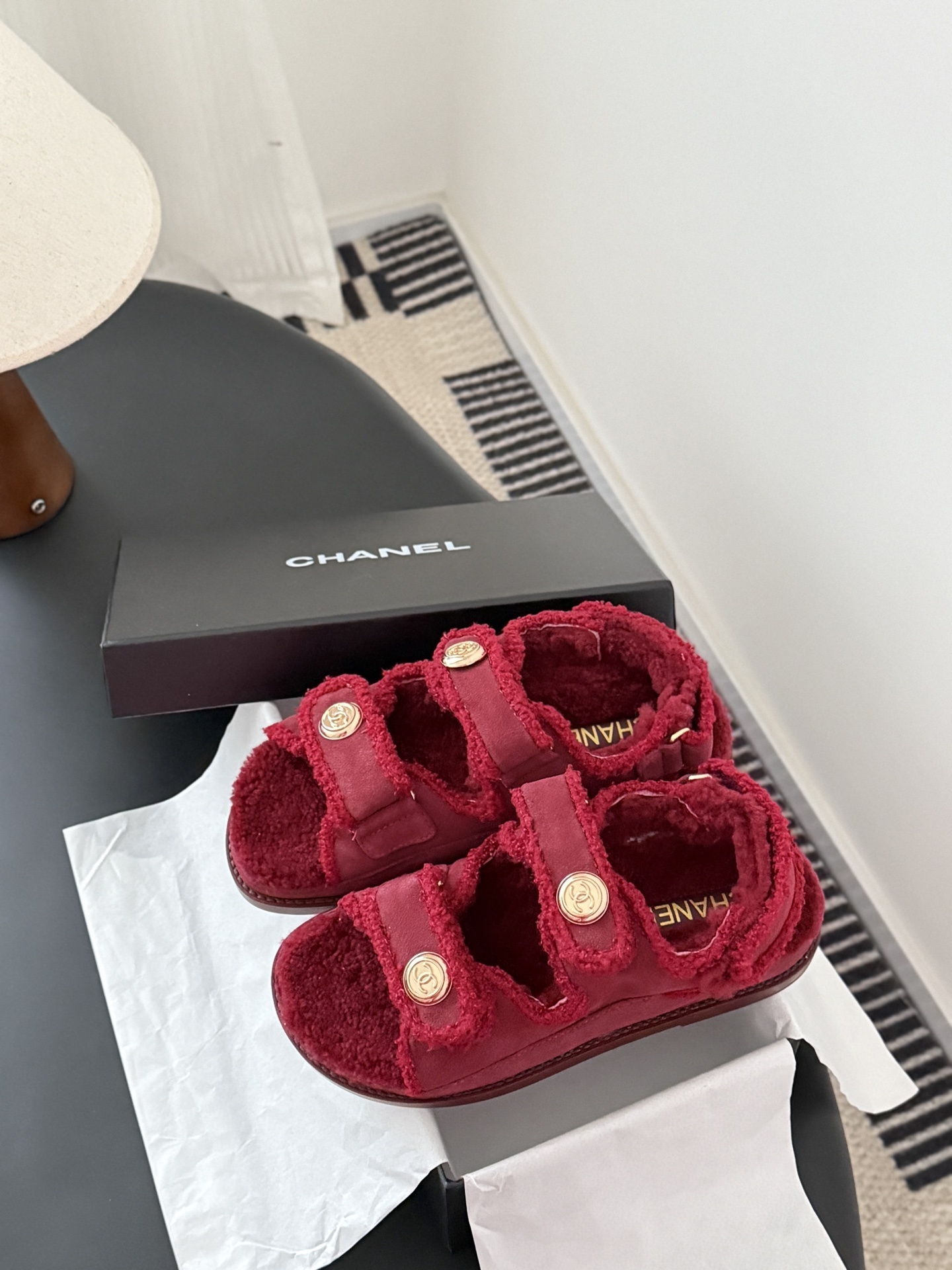 Top view of red Chanel shearling sandals with gold CC logo buttons and black designer box - Hình 9