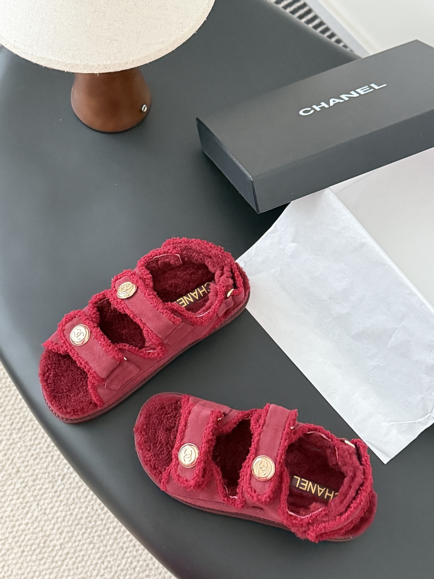 Top view of red Chanel shearling sandals with gold CC logo buttons and black designer box - Hình 6