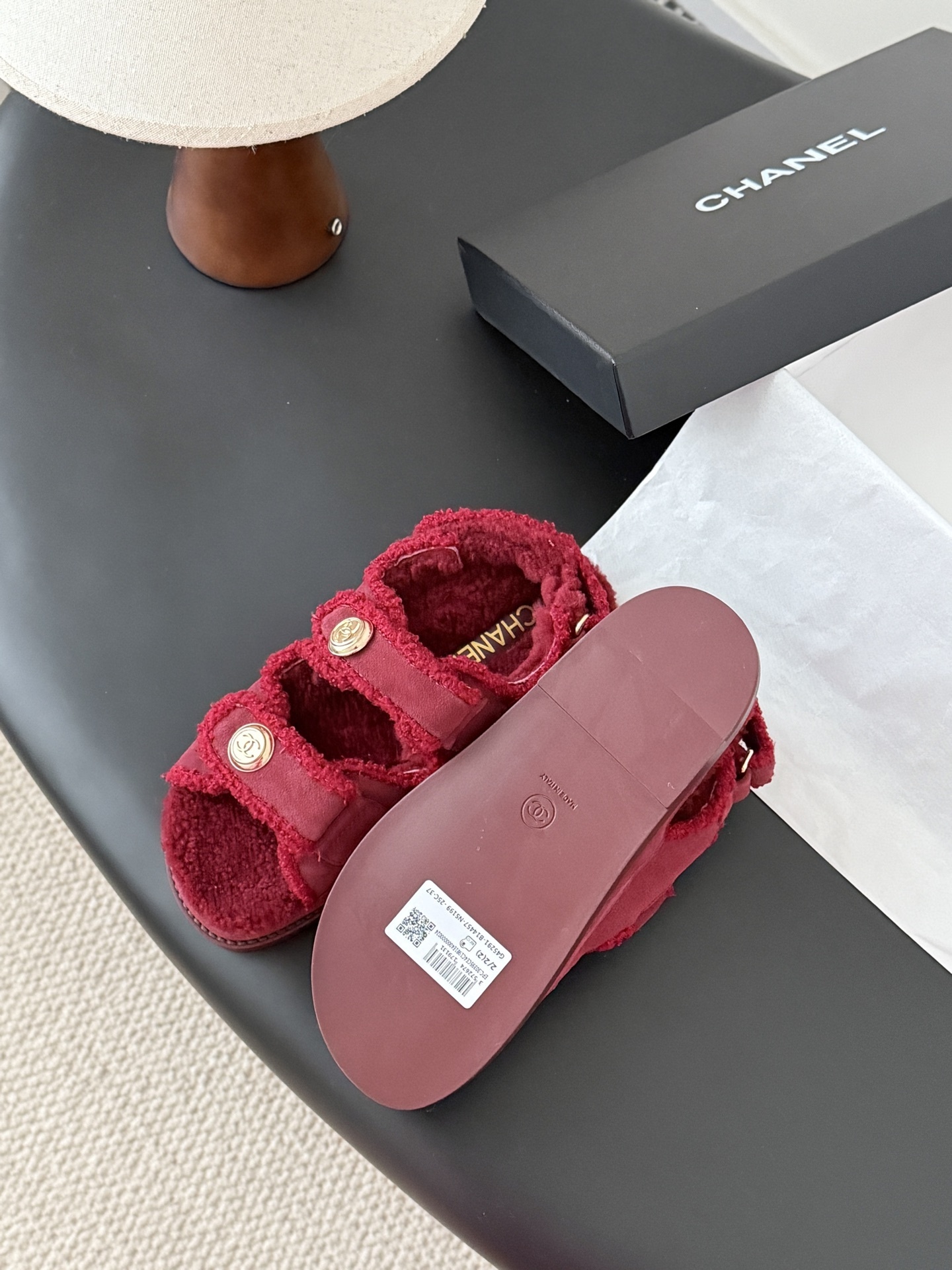Top view of red Chanel shearling sandals with gold CC logo buttons and black designer box - Hình 5