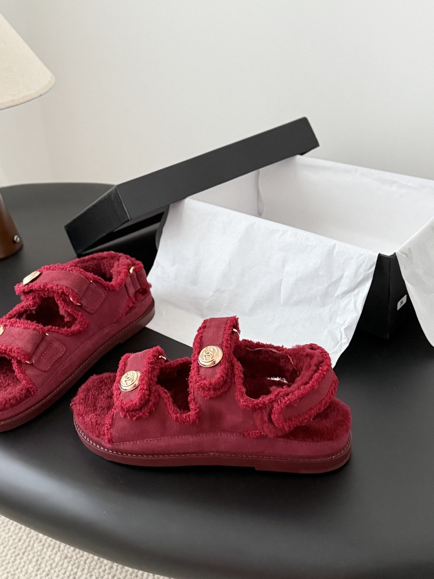 Top view of red Chanel shearling sandals with gold CC logo buttons and black designer box - Hình 2