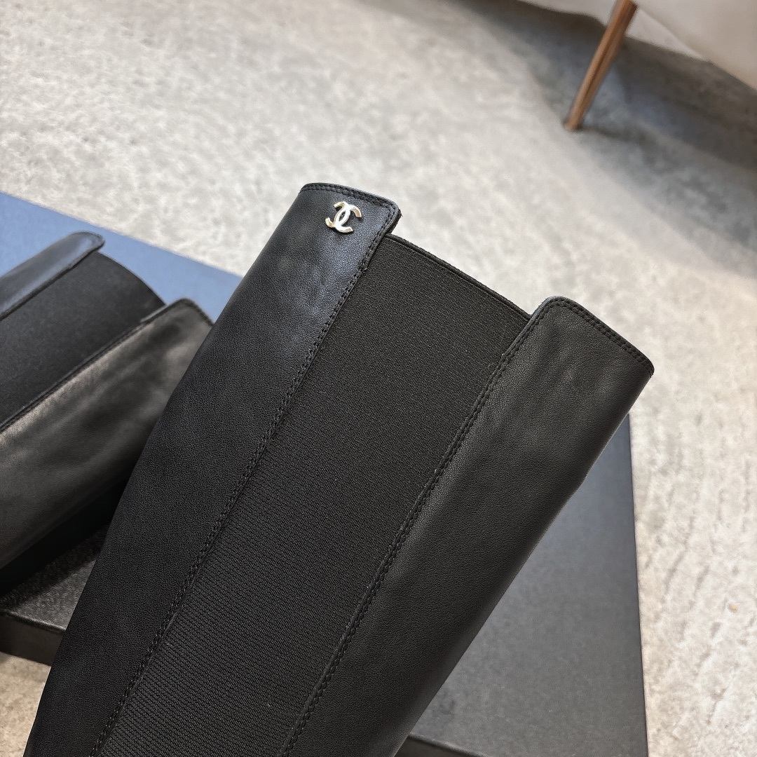 Chanel black leather knee-high boots with chunky lug soles and gold CC logo on a black box - Hình 8