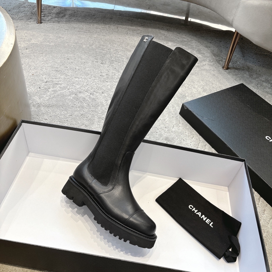 Chanel black leather knee-high boots with chunky lug soles and gold CC logo on a black box - Hình 6