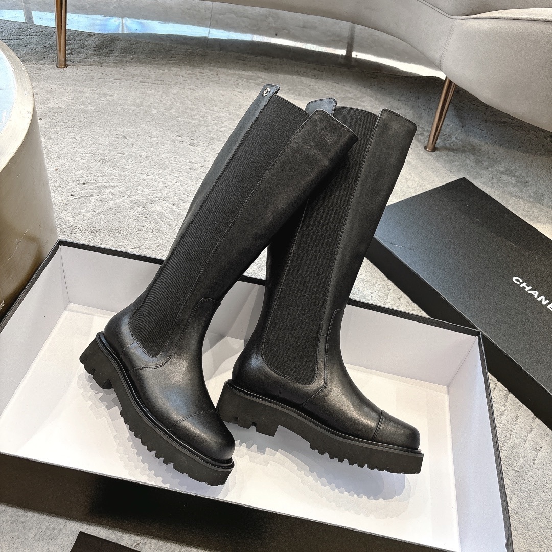 Chanel black leather knee-high boots with chunky lug soles and gold CC logo on a black box - Hình 4