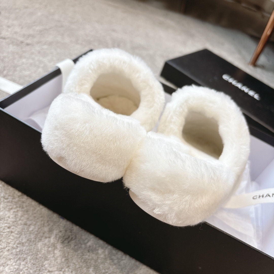 A pair of plush white faux fur slippers with a designer logo embroidery in a black gift box with white ribbon. - Hình 9
