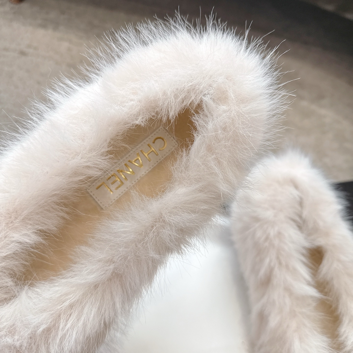 A pair of luxury white faux fur ballerina flats with black toe caps and silver CC logos, presented in a designer box. - Hình 8