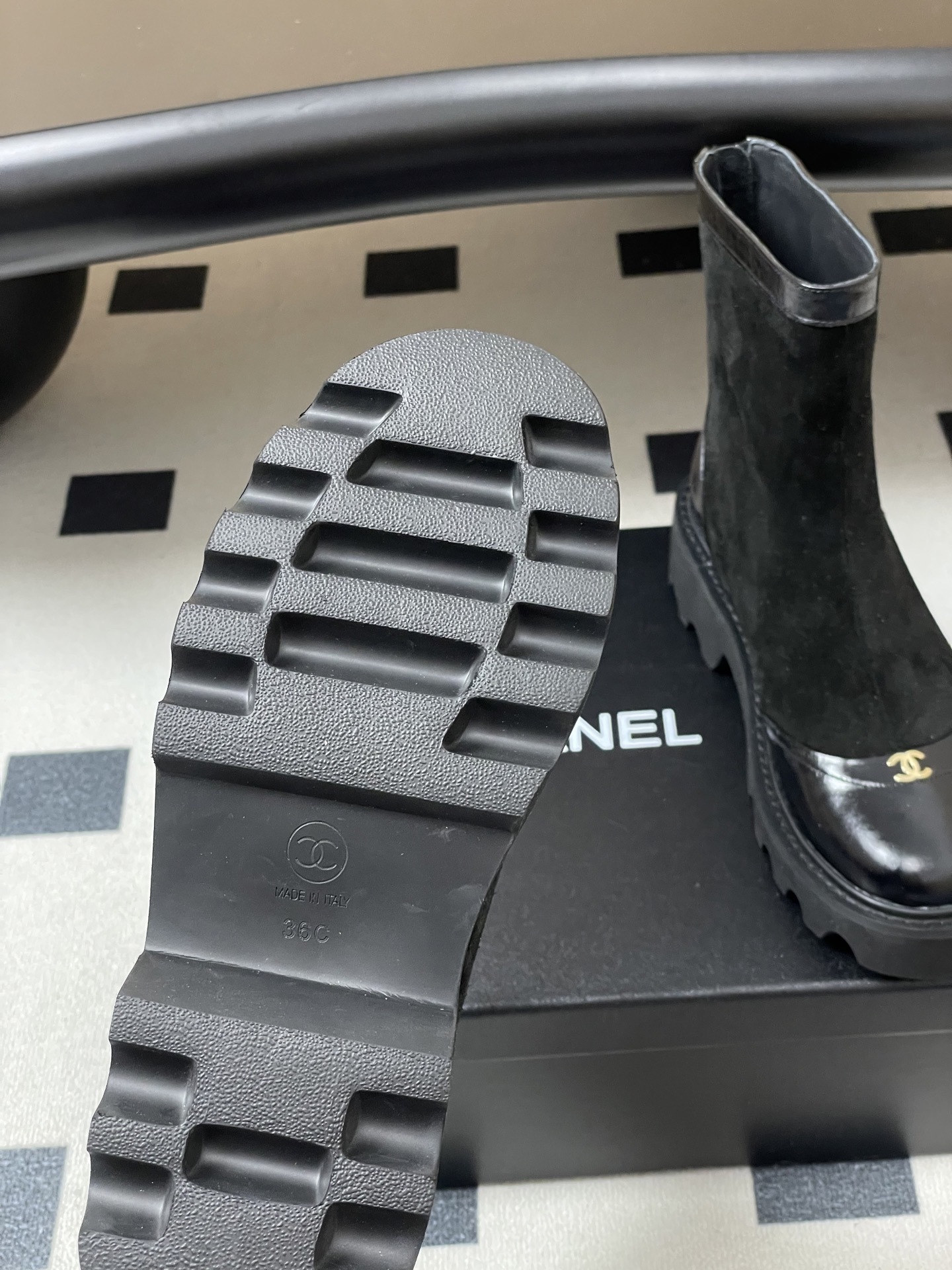 A pair of Chanel black suede ankle boots with patent leather toe caps, gold CC logos, and chunky lug soles. - Hình 8