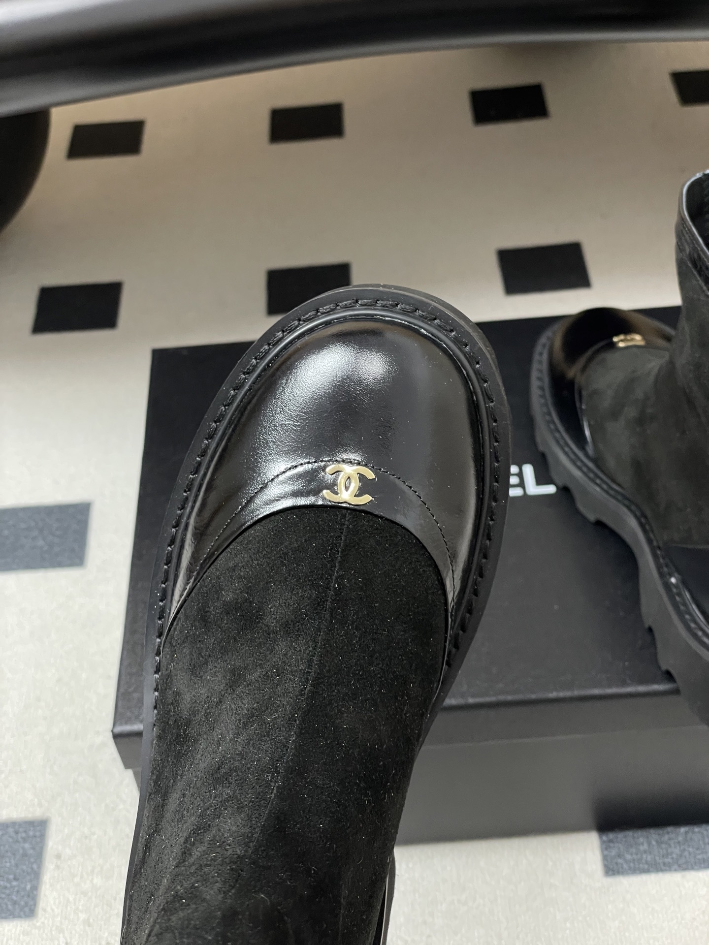 A pair of Chanel black suede ankle boots with patent leather toe caps, gold CC logos, and chunky lug soles. - Hình 7