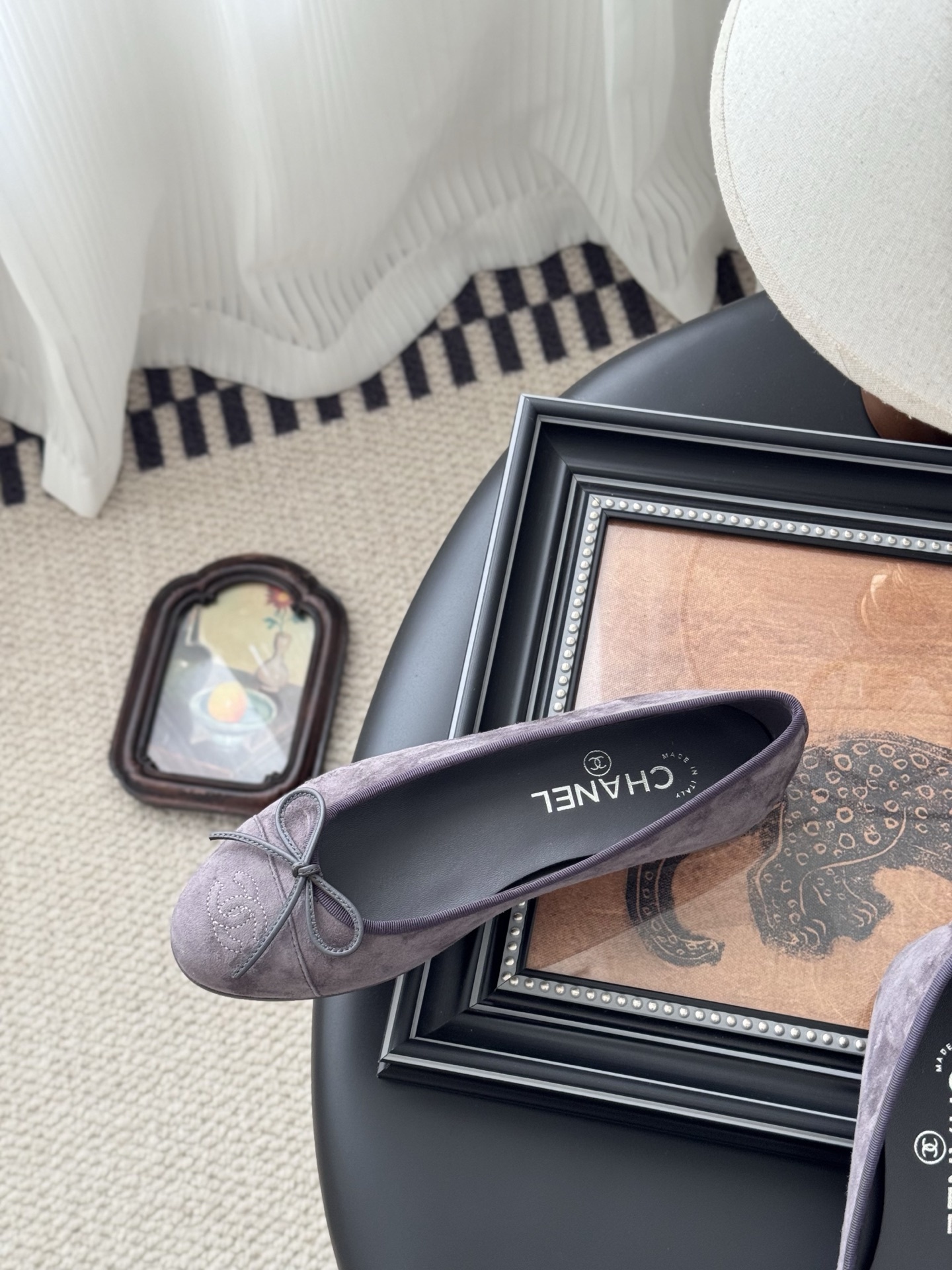 A pair of mauve suede Chanel ballerina flats featuring a bow and CC logo, displayed with a Chanel box. - Hình 8